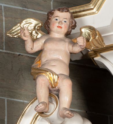 Zdjęcie nr 29: Ołtarz jednoosiowy, jednokondygnacyjny, ze zwieńczeniem. Mensa umieszczona na tumbie zwężającej się ku dołowi, ozdobionej od czoła płyciną prostokątną w złoconym obramieniu, pośrodku ze splecionymi literami imienia Maria. Nastawa flankowana ustawionymi ukośnie czworobocznymi, kanelowanymi filarami, dźwigającymi odcinki pełnego belkowania i gzymsu, przerwanych nad polem środkowym. Na tle filarów umieszczone na konsolach rzeźby: św. Stanisława Kostki (po lewej) i św. Ignacego Loyoli (po prawej). W polu środkowym, nad mensą zawieszony obraz w ozdobnej ramie z przedstawieniem św. Stanisława Kostki w półpostaci; wyżej prostokątna nisza, w której obraz Matki Boskiej z Dzieciątkiem. Zwieńczenie w kształcie aediculi zamkniętej łukiem półkolistym nadwieszonym, w której polu obraz z przedstawieniem św. Józefa w półpostaci. Po bokach, w osiach filarów odcinki przerwanego przyczółka na których rzeźby nagich, uskrzydlonych puttów.  Na gzymsie wieńczącym ołtarz Gołębica Ducha Świętego wśród promieni.