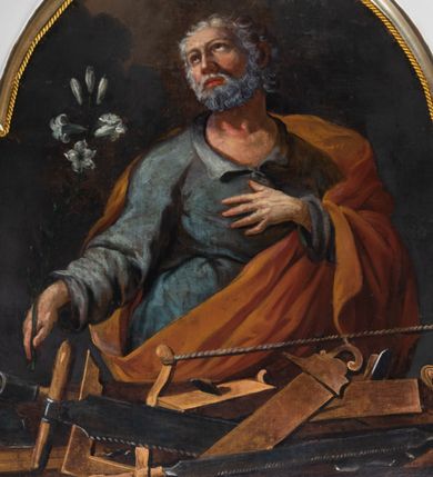 Zdjęcie nr 4: Obraz w kształcie prostokąta o wklęsłych bokach, zamkniętego łukiem półkolistym nadwieszonym, powtarzającym kształt zwieńczenia, z przedstawieniem św. Józefa w półpostaci. Święty ukazany jako starszy mężczyzna, frontalnie, z głową zwróconą lekko w prawo i wzrokiem skierowanym ku górze. Twarz pełna, z wysokim czołem i prostym nosem, okolona krótkimi kędzierzawymi, siwymi włosami i takimż zarostem. W prawej ręce, odwiedzionej od ciała nieco w bok i wyciągniętej do przodu, trzyma białą lilię, lewa ręka ugięta w łokciu, z dłonią przyłożoną do piersi. Ubrany w niebieską suknię z rozcięciem na piersi i szerokimi rękawami; okryty czerwonym płaszczem zarzuconym na lewe ramię, z prawą połą przełożoną przez przód postaci i przerzuconą przez lewe przedramię. Przed nim na pierwszym planie rozłożone narzędzia ciesielskie. W tle niebo i skłębione obłoki.  