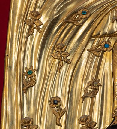 Zdjęcie nr 3: Przedstawienie Matki Boskiej z Dzieciątkiem w typie Matki Boskiej Śnieżnej. Twarz Marii, głowa i stopy Dzieciątka oraz dłonie malowane; szaty Marii i Dzieciątka promieniste nimby wokół głów oraz zamknięte korony wykonane z trybowanej złoconej blachy, ozdobione motywami kwiatów i kameryzacją. Tło z czerwonego aksamitu.