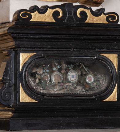 Zdjęcie nr 5: Rzeźba pełnoplastyczna, przyścienna, ustawiona na prostopadłościennym, wykonanym z czarnego marmuru relikwiarzu różnych świętych. Święty przedstawiony w całej postaci, stoi w lekkim kontrapoście, z rękami ugiętymi w łokciach, prawą dłonią trzyma rękojeść długiego srebrzystego miecza. Twarz pociągła okolona kędzierzawymi siwymi włosami i długą brodą. Ubrany w długą, sięgającą do kostek złotą  suknię i zarzucony na ramiona złoty płaszcz. 