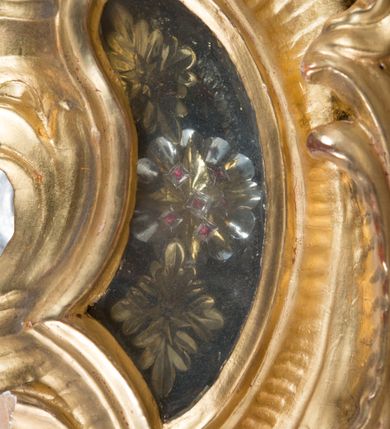 Zdjęcie nr 7: Feretron dwustronny z płaskorzeźbą Najświętszej Marii Panny Niepokalanie Poczętej na awersie oraz płaskorzeźbą ze sceną Narodzenia Najświętszej Marii Panny na rewersie, ustawiony na niskim postumencie o fantazyjnym wykroju z osią główną wysuniętą do przodu oraz narożnikami ustawionymi ukośnie. W postumencie dziewięć przeszklonych gablotek mieszczących relikwie świętych, które opisane są na małych karteczkach, otoczone różnego rodzaju kwiatkami  i gwiazdkami wykonanymi z papieru i cienkich blaszek. Otwory gablotek  o różnorodnym, fantazyjnym, opływowym wykroju. Na górnej powierzchni podstawy, po bokach małe otwory po zatkniętych w nich, niezachowanych rzeźbach apostołów. Rama obrazów w kształcie stojącego prostokąta, ujęta po każdej stronie trzema gablotkami otoczonymi rzeźbionym ornamentem rocaille'owym. W zwieńczeniu takie same, mniejsze gablotki, pośrodku zamiast relikwii owalna plakietka z kości z przedstawieniem Ucieczki do Egiptu. W zwieńczeniu na obłokach dwa aniołki podtrzymujące koronę. Na rewersie struktura feretronu o takim samym kształcie. Podstawa zdobiona gęstą wicią ze stylizowanych liści akantu zamkniętą w kształcie prostokąta leżącego.  Po bokach zamiast gablotek owoidalne pola, w których znajduje się złocona, drobna kratka.  W zwieńczeniu, w polu środkowym monogram Marii, powyżej aniołki trzymające koronę widoczne od tyłu.

Na awersie płaskorzeźba z przedstawieniem Najświętszej Marii Panny Niepokalanie Poczętej. Maria ukazana w postawie stojącej, frontalnie, na półksiężycu  i globie ziemskim, depcząca bosymi stopami węża, ze złożonymi w geście modlitwy rękami, z głową delikatnie przechyloną w prawą stronę. Twarz owalna z małymi i wąskimi ustami, wzrokiem skierowanym w dal. Włosy jasnobrązowe z przedziałkiem pośrodku, skryte pod płaszczem. Ubrana w długą, złoconą suknię z długimi rękawami, przewiązaną pod biustem oraz złoty płaszcz założony  na głowę i otulający całą postać, z lewym końcem przerzuconym przez prawe przedramię. W dolnej partii płaszcza oraz na prawej piersi ryta dekoracja roślinna, składająca się z sześciu ulistnionych gałązek z pięcio- lub sześciopłatkowymi kwiatkami. Wokół całej postaci Marii otok z srebrnych obłoków oraz promieni naprzemiennie prostych  i falujących. Wokół głowy złoty, kolisty nimb z gęsto ułożonych promieni; na nim okrąg z gwiazd dwunastu, częściowo nie zachowany. Tło srebrne, zdobione złoconą  i płaskorzeźbioną wicią z liści stylizujących suchy akant.

Na rewersie płaskorzeźba z przedstawieniem Narodzenia Najświętszej Marii Panny. Kompozycja dwustrefowa, w dolnej partii ukazani św. Joachim i św. Anna, w górnej Bóg Ojciec i Matka Boska w otoczeniu uskrzydlonych główek anielskich. Rodzice Marii w pozycji klęczącej, zwróceni trzy czwarte  ku środkowi. Ubrani w długie i złocone suknie z długimi rękawami oraz złote płaszcze, św. Anna z welonem na głowie. Pomiędzy nimi ustawiona ukośnie kołyska, ozdobiona na narożu uskrzydloną główką aniołka, przykryta długą tkaniną. U nóg św. Anny zamknięta księga, na obwolucie zdobiona prostym, łacińskim krzyżykiem. Po prawej stronie obrazu, za św. Anną, na wysokim postumencie antykizujący dzban. W górnej partii kompozycji Bóg Ojciec widoczny w półpostaci, frontalnie,  w lewym ręku trzymający jabłko królewskie, prawą wyciągający ku Marii. Ubrany  w złotą szatę z długimi rękawami oraz złoty płaszcz z rozwianym jednym końcem  po jego prawej stronie, wokół głowy złoty i trójkątny nimb. Twarz okolona gęstą i siwą brodą oraz siwymi, średniej długości włosami. Maria ukazana poniżej Boga Ojca,  w młodzieńczym wieku, w postawie stojącej na półksiężycu, frontalnie, z rękami złożonymi w geście modlitwy. Ubrana w długą i złotą suknię z długimi rękawami oraz złoty płaszcz, którego koniec przerzucony przez lewe ramię; wokół głowy złoty okrągły nimb. Włosy długie i jasnobrązowe, opadające na plecy. Tło utworzone  z obłoków. Wokół Boga Ojca i Marii cztery uskrzydlone główki aniołków o wyraźnie zaznaczonych pucułowatych policzkach. 

Relikwie  świętych umieszczone w niewielkich gablotkach za szybkami, opisane na karteczkach. Zwieńczenie feretronu, od lewej: nierozpoznane relikwie świętego, plakietka z kości  z przedstawieniem Ucieczki do Egiptu, relikwie „Sancta THERESIA Virgo”  Prawy bok feretronu, od góry: relikwie „Sanctae Katarzyny Panny”, relikwie „Sanctae Rozalii Panny”, relikwie „Sancta Illuminata Martir”. Podstawa feretronu, od lewej: relikwie „Sanctus Benedicti Martyr, Sancta Victoria Virgo Martyr, Sancti Floryana Męczennika”; relikwie „Sanctae Marciana Virgo Martyr”; relikwie  „Sanctus Quirini Martir”; relikwie „Sancti Jucundina Martyr”; relikwie „Sanctus Mansueti M.,  Sancta Eugenia Virgo Martyr, Sanctae Bronisławy”. Lewy bok feretronu, od góry: relikwie „Sanctus Jana Kantego”, relikwie „Sanctae Honorati Martyr”, relikwie „Sancta Illuminata Martir”. Plakietka ze sceną ucieczki do Egiptu o kształcie owalnym. W centrum kompozycji ukazani św. Józef oraz Maria z Dzieciątkiem Jezus na osiołku. Wokół słabo czytelny napis: „Cetur doms(e) in aeg vivo[?].” Rzeźby aniołków w zwieńczeniu usytuowane przeciwstawnie, diagonalnie, zwrócone górną partią ciała ku środkowi, jedną ręką podtrzymujące koronę. Ubrane w wąską tkaninę przerzuconą przez jedno z ramion i zwiewnie opadającą w dół. Korona w typie zamkniętym. Struktura feretronu złocona i srebrzona.	