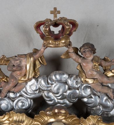 Zdjęcie nr 5: Feretron dwustronny z płaskorzeźbą Najświętszej Marii Panny Niepokalanie Poczętej na awersie oraz płaskorzeźbą ze sceną Narodzenia Najświętszej Marii Panny na rewersie, ustawiony na niskim postumencie o fantazyjnym wykroju z osią główną wysuniętą do przodu oraz narożnikami ustawionymi ukośnie. W postumencie dziewięć przeszklonych gablotek mieszczących relikwie świętych, które opisane są na małych karteczkach, otoczone różnego rodzaju kwiatkami  i gwiazdkami wykonanymi z papieru i cienkich blaszek. Otwory gablotek  o różnorodnym, fantazyjnym, opływowym wykroju. Na górnej powierzchni podstawy, po bokach małe otwory po zatkniętych w nich, niezachowanych rzeźbach apostołów. Rama obrazów w kształcie stojącego prostokąta, ujęta po każdej stronie trzema gablotkami otoczonymi rzeźbionym ornamentem rocaille'owym. W zwieńczeniu takie same, mniejsze gablotki, pośrodku zamiast relikwii owalna plakietka z kości z przedstawieniem Ucieczki do Egiptu. W zwieńczeniu na obłokach dwa aniołki podtrzymujące koronę. Na rewersie struktura feretronu o takim samym kształcie. Podstawa zdobiona gęstą wicią ze stylizowanych liści akantu zamkniętą w kształcie prostokąta leżącego.  Po bokach zamiast gablotek owoidalne pola, w których znajduje się złocona, drobna kratka.  W zwieńczeniu, w polu środkowym monogram Marii, powyżej aniołki trzymające koronę widoczne od tyłu.

Na awersie płaskorzeźba z przedstawieniem Najświętszej Marii Panny Niepokalanie Poczętej. Maria ukazana w postawie stojącej, frontalnie, na półksiężycu  i globie ziemskim, depcząca bosymi stopami węża, ze złożonymi w geście modlitwy rękami, z głową delikatnie przechyloną w prawą stronę. Twarz owalna z małymi i wąskimi ustami, wzrokiem skierowanym w dal. Włosy jasnobrązowe z przedziałkiem pośrodku, skryte pod płaszczem. Ubrana w długą, złoconą suknię z długimi rękawami, przewiązaną pod biustem oraz złoty płaszcz założony  na głowę i otulający całą postać, z lewym końcem przerzuconym przez prawe przedramię. W dolnej partii płaszcza oraz na prawej piersi ryta dekoracja roślinna, składająca się z sześciu ulistnionych gałązek z pięcio- lub sześciopłatkowymi kwiatkami. Wokół całej postaci Marii otok z srebrnych obłoków oraz promieni naprzemiennie prostych  i falujących. Wokół głowy złoty, kolisty nimb z gęsto ułożonych promieni; na nim okrąg z gwiazd dwunastu, częściowo nie zachowany. Tło srebrne, zdobione złoconą  i płaskorzeźbioną wicią z liści stylizujących suchy akant.

Na rewersie płaskorzeźba z przedstawieniem Narodzenia Najświętszej Marii Panny. Kompozycja dwustrefowa, w dolnej partii ukazani św. Joachim i św. Anna, w górnej Bóg Ojciec i Matka Boska w otoczeniu uskrzydlonych główek anielskich. Rodzice Marii w pozycji klęczącej, zwróceni trzy czwarte  ku środkowi. Ubrani w długie i złocone suknie z długimi rękawami oraz złote płaszcze, św. Anna z welonem na głowie. Pomiędzy nimi ustawiona ukośnie kołyska, ozdobiona na narożu uskrzydloną główką aniołka, przykryta długą tkaniną. U nóg św. Anny zamknięta księga, na obwolucie zdobiona prostym, łacińskim krzyżykiem. Po prawej stronie obrazu, za św. Anną, na wysokim postumencie antykizujący dzban. W górnej partii kompozycji Bóg Ojciec widoczny w półpostaci, frontalnie,  w lewym ręku trzymający jabłko królewskie, prawą wyciągający ku Marii. Ubrany  w złotą szatę z długimi rękawami oraz złoty płaszcz z rozwianym jednym końcem  po jego prawej stronie, wokół głowy złoty i trójkątny nimb. Twarz okolona gęstą i siwą brodą oraz siwymi, średniej długości włosami. Maria ukazana poniżej Boga Ojca,  w młodzieńczym wieku, w postawie stojącej na półksiężycu, frontalnie, z rękami złożonymi w geście modlitwy. Ubrana w długą i złotą suknię z długimi rękawami oraz złoty płaszcz, którego koniec przerzucony przez lewe ramię; wokół głowy złoty okrągły nimb. Włosy długie i jasnobrązowe, opadające na plecy. Tło utworzone  z obłoków. Wokół Boga Ojca i Marii cztery uskrzydlone główki aniołków o wyraźnie zaznaczonych pucułowatych policzkach. 

Relikwie  świętych umieszczone w niewielkich gablotkach za szybkami, opisane na karteczkach. Zwieńczenie feretronu, od lewej: nierozpoznane relikwie świętego, plakietka z kości  z przedstawieniem Ucieczki do Egiptu, relikwie „Sancta THERESIA Virgo”  Prawy bok feretronu, od góry: relikwie „Sanctae Katarzyny Panny”, relikwie „Sanctae Rozalii Panny”, relikwie „Sancta Illuminata Martir”. Podstawa feretronu, od lewej: relikwie „Sanctus Benedicti Martyr, Sancta Victoria Virgo Martyr, Sancti Floryana Męczennika”; relikwie „Sanctae Marciana Virgo Martyr”; relikwie  „Sanctus Quirini Martir”; relikwie „Sancti Jucundina Martyr”; relikwie „Sanctus Mansueti M.,  Sancta Eugenia Virgo Martyr, Sanctae Bronisławy”. Lewy bok feretronu, od góry: relikwie „Sanctus Jana Kantego”, relikwie „Sanctae Honorati Martyr”, relikwie „Sancta Illuminata Martir”. Plakietka ze sceną ucieczki do Egiptu o kształcie owalnym. W centrum kompozycji ukazani św. Józef oraz Maria z Dzieciątkiem Jezus na osiołku. Wokół słabo czytelny napis: „Cetur doms(e) in aeg vivo[?].” Rzeźby aniołków w zwieńczeniu usytuowane przeciwstawnie, diagonalnie, zwrócone górną partią ciała ku środkowi, jedną ręką podtrzymujące koronę. Ubrane w wąską tkaninę przerzuconą przez jedno z ramion i zwiewnie opadającą w dół. Korona w typie zamkniętym. Struktura feretronu złocona i srebrzona.	