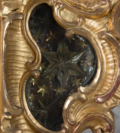 Zdjęcie nr 11: Feretron dwustronny z płaskorzeźbą Najświętszej Marii Panny Niepokalanie Poczętej na awersie oraz płaskorzeźbą ze sceną Narodzenia Najświętszej Marii Panny na rewersie, ustawiony na niskim postumencie o fantazyjnym wykroju z osią główną wysuniętą do przodu oraz narożnikami ustawionymi ukośnie. W postumencie dziewięć przeszklonych gablotek mieszczących relikwie świętych, które opisane są na małych karteczkach, otoczone różnego rodzaju kwiatkami  i gwiazdkami wykonanymi z papieru i cienkich blaszek. Otwory gablotek  o różnorodnym, fantazyjnym, opływowym wykroju. Na górnej powierzchni podstawy, po bokach małe otwory po zatkniętych w nich, niezachowanych rzeźbach apostołów. Rama obrazów w kształcie stojącego prostokąta, ujęta po każdej stronie trzema gablotkami otoczonymi rzeźbionym ornamentem rocaille&#039;owym. W zwieńczeniu takie same, mniejsze gablotki, pośrodku zamiast relikwii owalna plakietka z kości z przedstawieniem Ucieczki do Egiptu. W zwieńczeniu na obłokach dwa aniołki podtrzymujące koronę. Na rewersie struktura feretronu o takim samym kształcie. Podstawa zdobiona gęstą wicią ze stylizowanych liści akantu zamkniętą w kształcie prostokąta leżącego.  Po bokach zamiast gablotek owoidalne pola, w których znajduje się złocona, drobna kratka.  W zwieńczeniu, w polu środkowym monogram Marii, powyżej aniołki trzymające koronę widoczne od tyłu.

Na awersie płaskorzeźba z przedstawieniem Najświętszej Marii Panny Niepokalanie Poczętej. Maria ukazana w postawie stojącej, frontalnie, na półksiężycu  i globie ziemskim, depcząca bosymi stopami węża, ze złożonymi w geście modlitwy rękami, z głową delikatnie przechyloną w prawą stronę. Twarz owalna z małymi i wąskimi ustami, wzrokiem skierowanym w dal. Włosy jasnobrązowe z przedziałkiem pośrodku, skryte pod płaszczem. Ubrana w długą, złoconą suknię z długimi rękawami, przewiązaną pod biustem oraz złoty płaszcz założony  na głowę i otulający całą postać, z lewym końcem przerzuconym przez prawe przedramię. W dolnej partii płaszcza oraz na prawej piersi ryta dekoracja roślinna, składająca się z sześciu ulistnionych gałązek z pięcio- lub sześciopłatkowymi kwiatkami. Wokół całej postaci Marii otok z srebrnych obłoków oraz promieni naprzemiennie prostych  i falujących. Wokół głowy złoty, kolisty nimb z gęsto ułożonych promieni; na nim okrąg z gwiazd dwunastu, częściowo nie zachowany. Tło srebrne, zdobione złoconą  i płaskorzeźbioną wicią z liści stylizujących suchy akant.

Na rewersie płaskorzeźba z przedstawieniem Narodzenia Najświętszej Marii Panny. Kompozycja dwustrefowa, w dolnej partii ukazani św. Joachim i św. Anna, w górnej Bóg Ojciec i Matka Boska w otoczeniu uskrzydlonych główek anielskich. Rodzice Marii w pozycji klęczącej, zwróceni trzy czwarte  ku środkowi. Ubrani w długie i złocone suknie z długimi rękawami oraz złote płaszcze, św. Anna z welonem na głowie. Pomiędzy nimi ustawiona ukośnie kołyska, ozdobiona na narożu uskrzydloną główką aniołka, przykryta długą tkaniną. U nóg św. Anny zamknięta księga, na obwolucie zdobiona prostym, łacińskim krzyżykiem. Po prawej stronie obrazu, za św. Anną, na wysokim postumencie antykizujący dzban. W górnej partii kompozycji Bóg Ojciec widoczny w półpostaci, frontalnie,  w lewym ręku trzymający jabłko królewskie, prawą wyciągający ku Marii. Ubrany  w złotą szatę z długimi rękawami oraz złoty płaszcz z rozwianym jednym końcem  po jego prawej stronie, wokół głowy złoty i trójkątny nimb. Twarz okolona gęstą i siwą brodą oraz siwymi, średniej długości włosami. Maria ukazana poniżej Boga Ojca,  w młodzieńczym wieku, w postawie stojącej na półksiężycu, frontalnie, z rękami złożonymi w geście modlitwy. Ubrana w długą i złotą suknię z długimi rękawami oraz złoty płaszcz, którego koniec przerzucony przez lewe ramię; wokół głowy złoty okrągły nimb. Włosy długie i jasnobrązowe, opadające na plecy. Tło utworzone  z obłoków. Wokół Boga Ojca i Marii cztery uskrzydlone główki aniołków o wyraźnie zaznaczonych pucułowatych policzkach. 

Relikwie  świętych umieszczone w niewielkich gablotkach za szybkami, opisane na karteczkach. Zwieńczenie feretronu, od lewej: nierozpoznane relikwie świętego, plakietka z kości  z przedstawieniem Ucieczki do Egiptu, relikwie „Sancta THERESIA Virgo”  Prawy bok feretronu, od góry: relikwie „Sanctae Katarzyny Panny”, relikwie „Sanctae Rozalii Panny”, relikwie „Sancta Illuminata Martir”. Podstawa feretronu, od lewej: relikwie „Sanctus Benedicti Martyr, Sancta Victoria Virgo Martyr, Sancti Floryana Męczennika”; relikwie „Sanctae Marciana Virgo Martyr”; relikwie  „Sanctus Quirini Martir”; relikwie „Sancti Jucundina Martyr”; relikwie „Sanctus Mansueti M.,  Sancta Eugenia Virgo Martyr, Sanctae Bronisławy”. Lewy bok feretronu, od góry: relikwie „Sanctus Jana Kantego”, relikwie „Sanctae Honorati Martyr”, relikwie „Sancta Illuminata Martir”. Plakietka ze sceną ucieczki do Egiptu o kształcie owalnym. W centrum kompozycji ukazani św. Józef oraz Maria z Dzieciątkiem Jezus na osiołku. Wokół słabo czytelny napis: „Cetur doms(e) in aeg vivo[?].” Rzeźby aniołków w zwieńczeniu usytuowane przeciwstawnie, diagonalnie, zwrócone górną partią ciała ku środkowi, jedną ręką podtrzymujące koronę. Ubrane w wąską tkaninę przerzuconą przez jedno z ramion i zwiewnie opadającą w dół. Korona w typie zamkniętym. Struktura feretronu złocona i srebrzona.	