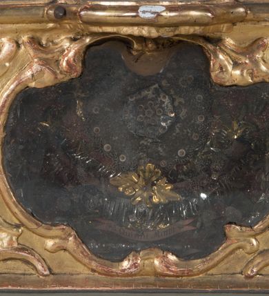 Zdjęcie nr 14: Feretron dwustronny z płaskorzeźbą Najświętszej Marii Panny Niepokalanie Poczętej na awersie oraz płaskorzeźbą ze sceną Narodzenia Najświętszej Marii Panny na rewersie, ustawiony na niskim postumencie o fantazyjnym wykroju z osią główną wysuniętą do przodu oraz narożnikami ustawionymi ukośnie. W postumencie dziewięć przeszklonych gablotek mieszczących relikwie świętych, które opisane są na małych karteczkach, otoczone różnego rodzaju kwiatkami  i gwiazdkami wykonanymi z papieru i cienkich blaszek. Otwory gablotek  o różnorodnym, fantazyjnym, opływowym wykroju. Na górnej powierzchni podstawy, po bokach małe otwory po zatkniętych w nich, niezachowanych rzeźbach apostołów. Rama obrazów w kształcie stojącego prostokąta, ujęta po każdej stronie trzema gablotkami otoczonymi rzeźbionym ornamentem rocaille'owym. W zwieńczeniu takie same, mniejsze gablotki, pośrodku zamiast relikwii owalna plakietka z kości z przedstawieniem Ucieczki do Egiptu. W zwieńczeniu na obłokach dwa aniołki podtrzymujące koronę. Na rewersie struktura feretronu o takim samym kształcie. Podstawa zdobiona gęstą wicią ze stylizowanych liści akantu zamkniętą w kształcie prostokąta leżącego.  Po bokach zamiast gablotek owoidalne pola, w których znajduje się złocona, drobna kratka.  W zwieńczeniu, w polu środkowym monogram Marii, powyżej aniołki trzymające koronę widoczne od tyłu.

Na awersie płaskorzeźba z przedstawieniem Najświętszej Marii Panny Niepokalanie Poczętej. Maria ukazana w postawie stojącej, frontalnie, na półksiężycu  i globie ziemskim, depcząca bosymi stopami węża, ze złożonymi w geście modlitwy rękami, z głową delikatnie przechyloną w prawą stronę. Twarz owalna z małymi i wąskimi ustami, wzrokiem skierowanym w dal. Włosy jasnobrązowe z przedziałkiem pośrodku, skryte pod płaszczem. Ubrana w długą, złoconą suknię z długimi rękawami, przewiązaną pod biustem oraz złoty płaszcz założony  na głowę i otulający całą postać, z lewym końcem przerzuconym przez prawe przedramię. W dolnej partii płaszcza oraz na prawej piersi ryta dekoracja roślinna, składająca się z sześciu ulistnionych gałązek z pięcio- lub sześciopłatkowymi kwiatkami. Wokół całej postaci Marii otok z srebrnych obłoków oraz promieni naprzemiennie prostych  i falujących. Wokół głowy złoty, kolisty nimb z gęsto ułożonych promieni; na nim okrąg z gwiazd dwunastu, częściowo nie zachowany. Tło srebrne, zdobione złoconą  i płaskorzeźbioną wicią z liści stylizujących suchy akant.

Na rewersie płaskorzeźba z przedstawieniem Narodzenia Najświętszej Marii Panny. Kompozycja dwustrefowa, w dolnej partii ukazani św. Joachim i św. Anna, w górnej Bóg Ojciec i Matka Boska w otoczeniu uskrzydlonych główek anielskich. Rodzice Marii w pozycji klęczącej, zwróceni trzy czwarte  ku środkowi. Ubrani w długie i złocone suknie z długimi rękawami oraz złote płaszcze, św. Anna z welonem na głowie. Pomiędzy nimi ustawiona ukośnie kołyska, ozdobiona na narożu uskrzydloną główką aniołka, przykryta długą tkaniną. U nóg św. Anny zamknięta księga, na obwolucie zdobiona prostym, łacińskim krzyżykiem. Po prawej stronie obrazu, za św. Anną, na wysokim postumencie antykizujący dzban. W górnej partii kompozycji Bóg Ojciec widoczny w półpostaci, frontalnie,  w lewym ręku trzymający jabłko królewskie, prawą wyciągający ku Marii. Ubrany  w złotą szatę z długimi rękawami oraz złoty płaszcz z rozwianym jednym końcem  po jego prawej stronie, wokół głowy złoty i trójkątny nimb. Twarz okolona gęstą i siwą brodą oraz siwymi, średniej długości włosami. Maria ukazana poniżej Boga Ojca,  w młodzieńczym wieku, w postawie stojącej na półksiężycu, frontalnie, z rękami złożonymi w geście modlitwy. Ubrana w długą i złotą suknię z długimi rękawami oraz złoty płaszcz, którego koniec przerzucony przez lewe ramię; wokół głowy złoty okrągły nimb. Włosy długie i jasnobrązowe, opadające na plecy. Tło utworzone  z obłoków. Wokół Boga Ojca i Marii cztery uskrzydlone główki aniołków o wyraźnie zaznaczonych pucułowatych policzkach. 

Relikwie  świętych umieszczone w niewielkich gablotkach za szybkami, opisane na karteczkach. Zwieńczenie feretronu, od lewej: nierozpoznane relikwie świętego, plakietka z kości  z przedstawieniem Ucieczki do Egiptu, relikwie „Sancta THERESIA Virgo”  Prawy bok feretronu, od góry: relikwie „Sanctae Katarzyny Panny”, relikwie „Sanctae Rozalii Panny”, relikwie „Sancta Illuminata Martir”. Podstawa feretronu, od lewej: relikwie „Sanctus Benedicti Martyr, Sancta Victoria Virgo Martyr, Sancti Floryana Męczennika”; relikwie „Sanctae Marciana Virgo Martyr”; relikwie  „Sanctus Quirini Martir”; relikwie „Sancti Jucundina Martyr”; relikwie „Sanctus Mansueti M.,  Sancta Eugenia Virgo Martyr, Sanctae Bronisławy”. Lewy bok feretronu, od góry: relikwie „Sanctus Jana Kantego”, relikwie „Sanctae Honorati Martyr”, relikwie „Sancta Illuminata Martir”. Plakietka ze sceną ucieczki do Egiptu o kształcie owalnym. W centrum kompozycji ukazani św. Józef oraz Maria z Dzieciątkiem Jezus na osiołku. Wokół słabo czytelny napis: „Cetur doms(e) in aeg vivo[?].” Rzeźby aniołków w zwieńczeniu usytuowane przeciwstawnie, diagonalnie, zwrócone górną partią ciała ku środkowi, jedną ręką podtrzymujące koronę. Ubrane w wąską tkaninę przerzuconą przez jedno z ramion i zwiewnie opadającą w dół. Korona w typie zamkniętym. Struktura feretronu złocona i srebrzona.	