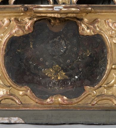 Zdjęcie nr 12: Feretron dwustronny z płaskorzeźbą Najświętszej Marii Panny Niepokalanie Poczętej na awersie oraz płaskorzeźbą ze sceną Narodzenia Najświętszej Marii Panny na rewersie, ustawiony na niskim postumencie o fantazyjnym wykroju z osią główną wysuniętą do przodu oraz narożnikami ustawionymi ukośnie. W postumencie dziewięć przeszklonych gablotek mieszczących relikwie świętych, które opisane są na małych karteczkach, otoczone różnego rodzaju kwiatkami  i gwiazdkami wykonanymi z papieru i cienkich blaszek. Otwory gablotek  o różnorodnym, fantazyjnym, opływowym wykroju. Na górnej powierzchni podstawy, po bokach małe otwory po zatkniętych w nich, niezachowanych rzeźbach apostołów. Rama obrazów w kształcie stojącego prostokąta, ujęta po każdej stronie trzema gablotkami otoczonymi rzeźbionym ornamentem rocaille'owym. W zwieńczeniu takie same, mniejsze gablotki, pośrodku zamiast relikwii owalna plakietka z kości z przedstawieniem Ucieczki do Egiptu. W zwieńczeniu na obłokach dwa aniołki podtrzymujące koronę. Na rewersie struktura feretronu o takim samym kształcie. Podstawa zdobiona gęstą wicią ze stylizowanych liści akantu zamkniętą w kształcie prostokąta leżącego.  Po bokach zamiast gablotek owoidalne pola, w których znajduje się złocona, drobna kratka.  W zwieńczeniu, w polu środkowym monogram Marii, powyżej aniołki trzymające koronę widoczne od tyłu.

Na awersie płaskorzeźba z przedstawieniem Najświętszej Marii Panny Niepokalanie Poczętej. Maria ukazana w postawie stojącej, frontalnie, na półksiężycu  i globie ziemskim, depcząca bosymi stopami węża, ze złożonymi w geście modlitwy rękami, z głową delikatnie przechyloną w prawą stronę. Twarz owalna z małymi i wąskimi ustami, wzrokiem skierowanym w dal. Włosy jasnobrązowe z przedziałkiem pośrodku, skryte pod płaszczem. Ubrana w długą, złoconą suknię z długimi rękawami, przewiązaną pod biustem oraz złoty płaszcz założony  na głowę i otulający całą postać, z lewym końcem przerzuconym przez prawe przedramię. W dolnej partii płaszcza oraz na prawej piersi ryta dekoracja roślinna, składająca się z sześciu ulistnionych gałązek z pięcio- lub sześciopłatkowymi kwiatkami. Wokół całej postaci Marii otok z srebrnych obłoków oraz promieni naprzemiennie prostych  i falujących. Wokół głowy złoty, kolisty nimb z gęsto ułożonych promieni; na nim okrąg z gwiazd dwunastu, częściowo nie zachowany. Tło srebrne, zdobione złoconą  i płaskorzeźbioną wicią z liści stylizujących suchy akant.

Na rewersie płaskorzeźba z przedstawieniem Narodzenia Najświętszej Marii Panny. Kompozycja dwustrefowa, w dolnej partii ukazani św. Joachim i św. Anna, w górnej Bóg Ojciec i Matka Boska w otoczeniu uskrzydlonych główek anielskich. Rodzice Marii w pozycji klęczącej, zwróceni trzy czwarte  ku środkowi. Ubrani w długie i złocone suknie z długimi rękawami oraz złote płaszcze, św. Anna z welonem na głowie. Pomiędzy nimi ustawiona ukośnie kołyska, ozdobiona na narożu uskrzydloną główką aniołka, przykryta długą tkaniną. U nóg św. Anny zamknięta księga, na obwolucie zdobiona prostym, łacińskim krzyżykiem. Po prawej stronie obrazu, za św. Anną, na wysokim postumencie antykizujący dzban. W górnej partii kompozycji Bóg Ojciec widoczny w półpostaci, frontalnie,  w lewym ręku trzymający jabłko królewskie, prawą wyciągający ku Marii. Ubrany  w złotą szatę z długimi rękawami oraz złoty płaszcz z rozwianym jednym końcem  po jego prawej stronie, wokół głowy złoty i trójkątny nimb. Twarz okolona gęstą i siwą brodą oraz siwymi, średniej długości włosami. Maria ukazana poniżej Boga Ojca,  w młodzieńczym wieku, w postawie stojącej na półksiężycu, frontalnie, z rękami złożonymi w geście modlitwy. Ubrana w długą i złotą suknię z długimi rękawami oraz złoty płaszcz, którego koniec przerzucony przez lewe ramię; wokół głowy złoty okrągły nimb. Włosy długie i jasnobrązowe, opadające na plecy. Tło utworzone  z obłoków. Wokół Boga Ojca i Marii cztery uskrzydlone główki aniołków o wyraźnie zaznaczonych pucułowatych policzkach. 

Relikwie  świętych umieszczone w niewielkich gablotkach za szybkami, opisane na karteczkach. Zwieńczenie feretronu, od lewej: nierozpoznane relikwie świętego, plakietka z kości  z przedstawieniem Ucieczki do Egiptu, relikwie „Sancta THERESIA Virgo”  Prawy bok feretronu, od góry: relikwie „Sanctae Katarzyny Panny”, relikwie „Sanctae Rozalii Panny”, relikwie „Sancta Illuminata Martir”. Podstawa feretronu, od lewej: relikwie „Sanctus Benedicti Martyr, Sancta Victoria Virgo Martyr, Sancti Floryana Męczennika”; relikwie „Sanctae Marciana Virgo Martyr”; relikwie  „Sanctus Quirini Martir”; relikwie „Sancti Jucundina Martyr”; relikwie „Sanctus Mansueti M.,  Sancta Eugenia Virgo Martyr, Sanctae Bronisławy”. Lewy bok feretronu, od góry: relikwie „Sanctus Jana Kantego”, relikwie „Sanctae Honorati Martyr”, relikwie „Sancta Illuminata Martir”. Plakietka ze sceną ucieczki do Egiptu o kształcie owalnym. W centrum kompozycji ukazani św. Józef oraz Maria z Dzieciątkiem Jezus na osiołku. Wokół słabo czytelny napis: „Cetur doms(e) in aeg vivo[?].” Rzeźby aniołków w zwieńczeniu usytuowane przeciwstawnie, diagonalnie, zwrócone górną partią ciała ku środkowi, jedną ręką podtrzymujące koronę. Ubrane w wąską tkaninę przerzuconą przez jedno z ramion i zwiewnie opadającą w dół. Korona w typie zamkniętym. Struktura feretronu złocona i srebrzona.	