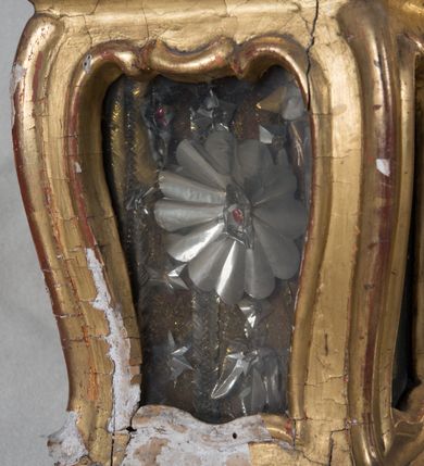 Zdjęcie nr 16: Feretron dwustronny z płaskorzeźbą Najświętszej Marii Panny Niepokalanie Poczętej na awersie oraz płaskorzeźbą ze sceną Narodzenia Najświętszej Marii Panny na rewersie, ustawiony na niskim postumencie o fantazyjnym wykroju z osią główną wysuniętą do przodu oraz narożnikami ustawionymi ukośnie. W postumencie dziewięć przeszklonych gablotek mieszczących relikwie świętych, które opisane są na małych karteczkach, otoczone różnego rodzaju kwiatkami  i gwiazdkami wykonanymi z papieru i cienkich blaszek. Otwory gablotek  o różnorodnym, fantazyjnym, opływowym wykroju. Na górnej powierzchni podstawy, po bokach małe otwory po zatkniętych w nich, niezachowanych rzeźbach apostołów. Rama obrazów w kształcie stojącego prostokąta, ujęta po każdej stronie trzema gablotkami otoczonymi rzeźbionym ornamentem rocaille&#039;owym. W zwieńczeniu takie same, mniejsze gablotki, pośrodku zamiast relikwii owalna plakietka z kości z przedstawieniem Ucieczki do Egiptu. W zwieńczeniu na obłokach dwa aniołki podtrzymujące koronę. Na rewersie struktura feretronu o takim samym kształcie. Podstawa zdobiona gęstą wicią ze stylizowanych liści akantu zamkniętą w kształcie prostokąta leżącego.  Po bokach zamiast gablotek owoidalne pola, w których znajduje się złocona, drobna kratka.  W zwieńczeniu, w polu środkowym monogram Marii, powyżej aniołki trzymające koronę widoczne od tyłu.

Na awersie płaskorzeźba z przedstawieniem Najświętszej Marii Panny Niepokalanie Poczętej. Maria ukazana w postawie stojącej, frontalnie, na półksiężycu  i globie ziemskim, depcząca bosymi stopami węża, ze złożonymi w geście modlitwy rękami, z głową delikatnie przechyloną w prawą stronę. Twarz owalna z małymi i wąskimi ustami, wzrokiem skierowanym w dal. Włosy jasnobrązowe z przedziałkiem pośrodku, skryte pod płaszczem. Ubrana w długą, złoconą suknię z długimi rękawami, przewiązaną pod biustem oraz złoty płaszcz założony  na głowę i otulający całą postać, z lewym końcem przerzuconym przez prawe przedramię. W dolnej partii płaszcza oraz na prawej piersi ryta dekoracja roślinna, składająca się z sześciu ulistnionych gałązek z pięcio- lub sześciopłatkowymi kwiatkami. Wokół całej postaci Marii otok z srebrnych obłoków oraz promieni naprzemiennie prostych  i falujących. Wokół głowy złoty, kolisty nimb z gęsto ułożonych promieni; na nim okrąg z gwiazd dwunastu, częściowo nie zachowany. Tło srebrne, zdobione złoconą  i płaskorzeźbioną wicią z liści stylizujących suchy akant.

Na rewersie płaskorzeźba z przedstawieniem Narodzenia Najświętszej Marii Panny. Kompozycja dwustrefowa, w dolnej partii ukazani św. Joachim i św. Anna, w górnej Bóg Ojciec i Matka Boska w otoczeniu uskrzydlonych główek anielskich. Rodzice Marii w pozycji klęczącej, zwróceni trzy czwarte  ku środkowi. Ubrani w długie i złocone suknie z długimi rękawami oraz złote płaszcze, św. Anna z welonem na głowie. Pomiędzy nimi ustawiona ukośnie kołyska, ozdobiona na narożu uskrzydloną główką aniołka, przykryta długą tkaniną. U nóg św. Anny zamknięta księga, na obwolucie zdobiona prostym, łacińskim krzyżykiem. Po prawej stronie obrazu, za św. Anną, na wysokim postumencie antykizujący dzban. W górnej partii kompozycji Bóg Ojciec widoczny w półpostaci, frontalnie,  w lewym ręku trzymający jabłko królewskie, prawą wyciągający ku Marii. Ubrany  w złotą szatę z długimi rękawami oraz złoty płaszcz z rozwianym jednym końcem  po jego prawej stronie, wokół głowy złoty i trójkątny nimb. Twarz okolona gęstą i siwą brodą oraz siwymi, średniej długości włosami. Maria ukazana poniżej Boga Ojca,  w młodzieńczym wieku, w postawie stojącej na półksiężycu, frontalnie, z rękami złożonymi w geście modlitwy. Ubrana w długą i złotą suknię z długimi rękawami oraz złoty płaszcz, którego koniec przerzucony przez lewe ramię; wokół głowy złoty okrągły nimb. Włosy długie i jasnobrązowe, opadające na plecy. Tło utworzone  z obłoków. Wokół Boga Ojca i Marii cztery uskrzydlone główki aniołków o wyraźnie zaznaczonych pucułowatych policzkach. 

Relikwie  świętych umieszczone w niewielkich gablotkach za szybkami, opisane na karteczkach. Zwieńczenie feretronu, od lewej: nierozpoznane relikwie świętego, plakietka z kości  z przedstawieniem Ucieczki do Egiptu, relikwie „Sancta THERESIA Virgo”  Prawy bok feretronu, od góry: relikwie „Sanctae Katarzyny Panny”, relikwie „Sanctae Rozalii Panny”, relikwie „Sancta Illuminata Martir”. Podstawa feretronu, od lewej: relikwie „Sanctus Benedicti Martyr, Sancta Victoria Virgo Martyr, Sancti Floryana Męczennika”; relikwie „Sanctae Marciana Virgo Martyr”; relikwie  „Sanctus Quirini Martir”; relikwie „Sancti Jucundina Martyr”; relikwie „Sanctus Mansueti M.,  Sancta Eugenia Virgo Martyr, Sanctae Bronisławy”. Lewy bok feretronu, od góry: relikwie „Sanctus Jana Kantego”, relikwie „Sanctae Honorati Martyr”, relikwie „Sancta Illuminata Martir”. Plakietka ze sceną ucieczki do Egiptu o kształcie owalnym. W centrum kompozycji ukazani św. Józef oraz Maria z Dzieciątkiem Jezus na osiołku. Wokół słabo czytelny napis: „Cetur doms(e) in aeg vivo[?].” Rzeźby aniołków w zwieńczeniu usytuowane przeciwstawnie, diagonalnie, zwrócone górną partią ciała ku środkowi, jedną ręką podtrzymujące koronę. Ubrane w wąską tkaninę przerzuconą przez jedno z ramion i zwiewnie opadającą w dół. Korona w typie zamkniętym. Struktura feretronu złocona i srebrzona.	