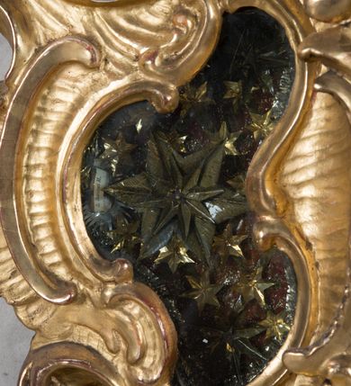 Zdjęcie nr 19: Feretron dwustronny z płaskorzeźbą Najświętszej Marii Panny Niepokalanie Poczętej na awersie oraz płaskorzeźbą ze sceną Narodzenia Najświętszej Marii Panny na rewersie, ustawiony na niskim postumencie o fantazyjnym wykroju z osią główną wysuniętą do przodu oraz narożnikami ustawionymi ukośnie. W postumencie dziewięć przeszklonych gablotek mieszczących relikwie świętych, które opisane są na małych karteczkach, otoczone różnego rodzaju kwiatkami  i gwiazdkami wykonanymi z papieru i cienkich blaszek. Otwory gablotek  o różnorodnym, fantazyjnym, opływowym wykroju. Na górnej powierzchni podstawy, po bokach małe otwory po zatkniętych w nich, niezachowanych rzeźbach apostołów. Rama obrazów w kształcie stojącego prostokąta, ujęta po każdej stronie trzema gablotkami otoczonymi rzeźbionym ornamentem rocaille'owym. W zwieńczeniu takie same, mniejsze gablotki, pośrodku zamiast relikwii owalna plakietka z kości z przedstawieniem Ucieczki do Egiptu. W zwieńczeniu na obłokach dwa aniołki podtrzymujące koronę. Na rewersie struktura feretronu o takim samym kształcie. Podstawa zdobiona gęstą wicią ze stylizowanych liści akantu zamkniętą w kształcie prostokąta leżącego.  Po bokach zamiast gablotek owoidalne pola, w których znajduje się złocona, drobna kratka.  W zwieńczeniu, w polu środkowym monogram Marii, powyżej aniołki trzymające koronę widoczne od tyłu.

Na awersie płaskorzeźba z przedstawieniem Najświętszej Marii Panny Niepokalanie Poczętej. Maria ukazana w postawie stojącej, frontalnie, na półksiężycu  i globie ziemskim, depcząca bosymi stopami węża, ze złożonymi w geście modlitwy rękami, z głową delikatnie przechyloną w prawą stronę. Twarz owalna z małymi i wąskimi ustami, wzrokiem skierowanym w dal. Włosy jasnobrązowe z przedziałkiem pośrodku, skryte pod płaszczem. Ubrana w długą, złoconą suknię z długimi rękawami, przewiązaną pod biustem oraz złoty płaszcz założony  na głowę i otulający całą postać, z lewym końcem przerzuconym przez prawe przedramię. W dolnej partii płaszcza oraz na prawej piersi ryta dekoracja roślinna, składająca się z sześciu ulistnionych gałązek z pięcio- lub sześciopłatkowymi kwiatkami. Wokół całej postaci Marii otok z srebrnych obłoków oraz promieni naprzemiennie prostych  i falujących. Wokół głowy złoty, kolisty nimb z gęsto ułożonych promieni; na nim okrąg z gwiazd dwunastu, częściowo nie zachowany. Tło srebrne, zdobione złoconą  i płaskorzeźbioną wicią z liści stylizujących suchy akant.

Na rewersie płaskorzeźba z przedstawieniem Narodzenia Najświętszej Marii Panny. Kompozycja dwustrefowa, w dolnej partii ukazani św. Joachim i św. Anna, w górnej Bóg Ojciec i Matka Boska w otoczeniu uskrzydlonych główek anielskich. Rodzice Marii w pozycji klęczącej, zwróceni trzy czwarte  ku środkowi. Ubrani w długie i złocone suknie z długimi rękawami oraz złote płaszcze, św. Anna z welonem na głowie. Pomiędzy nimi ustawiona ukośnie kołyska, ozdobiona na narożu uskrzydloną główką aniołka, przykryta długą tkaniną. U nóg św. Anny zamknięta księga, na obwolucie zdobiona prostym, łacińskim krzyżykiem. Po prawej stronie obrazu, za św. Anną, na wysokim postumencie antykizujący dzban. W górnej partii kompozycji Bóg Ojciec widoczny w półpostaci, frontalnie,  w lewym ręku trzymający jabłko królewskie, prawą wyciągający ku Marii. Ubrany  w złotą szatę z długimi rękawami oraz złoty płaszcz z rozwianym jednym końcem  po jego prawej stronie, wokół głowy złoty i trójkątny nimb. Twarz okolona gęstą i siwą brodą oraz siwymi, średniej długości włosami. Maria ukazana poniżej Boga Ojca,  w młodzieńczym wieku, w postawie stojącej na półksiężycu, frontalnie, z rękami złożonymi w geście modlitwy. Ubrana w długą i złotą suknię z długimi rękawami oraz złoty płaszcz, którego koniec przerzucony przez lewe ramię; wokół głowy złoty okrągły nimb. Włosy długie i jasnobrązowe, opadające na plecy. Tło utworzone  z obłoków. Wokół Boga Ojca i Marii cztery uskrzydlone główki aniołków o wyraźnie zaznaczonych pucułowatych policzkach. 

Relikwie  świętych umieszczone w niewielkich gablotkach za szybkami, opisane na karteczkach. Zwieńczenie feretronu, od lewej: nierozpoznane relikwie świętego, plakietka z kości  z przedstawieniem Ucieczki do Egiptu, relikwie „Sancta THERESIA Virgo”  Prawy bok feretronu, od góry: relikwie „Sanctae Katarzyny Panny”, relikwie „Sanctae Rozalii Panny”, relikwie „Sancta Illuminata Martir”. Podstawa feretronu, od lewej: relikwie „Sanctus Benedicti Martyr, Sancta Victoria Virgo Martyr, Sancti Floryana Męczennika”; relikwie „Sanctae Marciana Virgo Martyr”; relikwie  „Sanctus Quirini Martir”; relikwie „Sancti Jucundina Martyr”; relikwie „Sanctus Mansueti M.,  Sancta Eugenia Virgo Martyr, Sanctae Bronisławy”. Lewy bok feretronu, od góry: relikwie „Sanctus Jana Kantego”, relikwie „Sanctae Honorati Martyr”, relikwie „Sancta Illuminata Martir”. Plakietka ze sceną ucieczki do Egiptu o kształcie owalnym. W centrum kompozycji ukazani św. Józef oraz Maria z Dzieciątkiem Jezus na osiołku. Wokół słabo czytelny napis: „Cetur doms(e) in aeg vivo[?].” Rzeźby aniołków w zwieńczeniu usytuowane przeciwstawnie, diagonalnie, zwrócone górną partią ciała ku środkowi, jedną ręką podtrzymujące koronę. Ubrane w wąską tkaninę przerzuconą przez jedno z ramion i zwiewnie opadającą w dół. Korona w typie zamkniętym. Struktura feretronu złocona i srebrzona.	