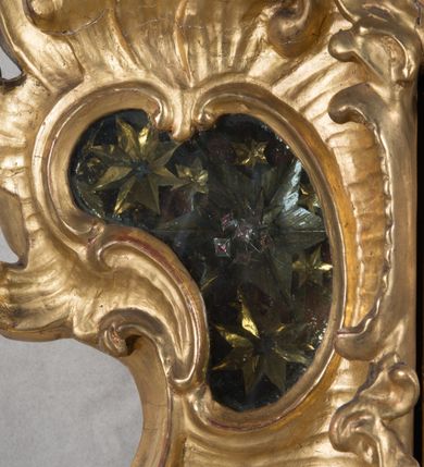 Zdjęcie nr 20: Feretron dwustronny z płaskorzeźbą Najświętszej Marii Panny Niepokalanie Poczętej na awersie oraz płaskorzeźbą ze sceną Narodzenia Najświętszej Marii Panny na rewersie, ustawiony na niskim postumencie o fantazyjnym wykroju z osią główną wysuniętą do przodu oraz narożnikami ustawionymi ukośnie. W postumencie dziewięć przeszklonych gablotek mieszczących relikwie świętych, które opisane są na małych karteczkach, otoczone różnego rodzaju kwiatkami  i gwiazdkami wykonanymi z papieru i cienkich blaszek. Otwory gablotek  o różnorodnym, fantazyjnym, opływowym wykroju. Na górnej powierzchni podstawy, po bokach małe otwory po zatkniętych w nich, niezachowanych rzeźbach apostołów. Rama obrazów w kształcie stojącego prostokąta, ujęta po każdej stronie trzema gablotkami otoczonymi rzeźbionym ornamentem rocaille&#039;owym. W zwieńczeniu takie same, mniejsze gablotki, pośrodku zamiast relikwii owalna plakietka z kości z przedstawieniem Ucieczki do Egiptu. W zwieńczeniu na obłokach dwa aniołki podtrzymujące koronę. Na rewersie struktura feretronu o takim samym kształcie. Podstawa zdobiona gęstą wicią ze stylizowanych liści akantu zamkniętą w kształcie prostokąta leżącego.  Po bokach zamiast gablotek owoidalne pola, w których znajduje się złocona, drobna kratka.  W zwieńczeniu, w polu środkowym monogram Marii, powyżej aniołki trzymające koronę widoczne od tyłu.

Na awersie płaskorzeźba z przedstawieniem Najświętszej Marii Panny Niepokalanie Poczętej. Maria ukazana w postawie stojącej, frontalnie, na półksiężycu  i globie ziemskim, depcząca bosymi stopami węża, ze złożonymi w geście modlitwy rękami, z głową delikatnie przechyloną w prawą stronę. Twarz owalna z małymi i wąskimi ustami, wzrokiem skierowanym w dal. Włosy jasnobrązowe z przedziałkiem pośrodku, skryte pod płaszczem. Ubrana w długą, złoconą suknię z długimi rękawami, przewiązaną pod biustem oraz złoty płaszcz założony  na głowę i otulający całą postać, z lewym końcem przerzuconym przez prawe przedramię. W dolnej partii płaszcza oraz na prawej piersi ryta dekoracja roślinna, składająca się z sześciu ulistnionych gałązek z pięcio- lub sześciopłatkowymi kwiatkami. Wokół całej postaci Marii otok z srebrnych obłoków oraz promieni naprzemiennie prostych  i falujących. Wokół głowy złoty, kolisty nimb z gęsto ułożonych promieni; na nim okrąg z gwiazd dwunastu, częściowo nie zachowany. Tło srebrne, zdobione złoconą  i płaskorzeźbioną wicią z liści stylizujących suchy akant.

Na rewersie płaskorzeźba z przedstawieniem Narodzenia Najświętszej Marii Panny. Kompozycja dwustrefowa, w dolnej partii ukazani św. Joachim i św. Anna, w górnej Bóg Ojciec i Matka Boska w otoczeniu uskrzydlonych główek anielskich. Rodzice Marii w pozycji klęczącej, zwróceni trzy czwarte  ku środkowi. Ubrani w długie i złocone suknie z długimi rękawami oraz złote płaszcze, św. Anna z welonem na głowie. Pomiędzy nimi ustawiona ukośnie kołyska, ozdobiona na narożu uskrzydloną główką aniołka, przykryta długą tkaniną. U nóg św. Anny zamknięta księga, na obwolucie zdobiona prostym, łacińskim krzyżykiem. Po prawej stronie obrazu, za św. Anną, na wysokim postumencie antykizujący dzban. W górnej partii kompozycji Bóg Ojciec widoczny w półpostaci, frontalnie,  w lewym ręku trzymający jabłko królewskie, prawą wyciągający ku Marii. Ubrany  w złotą szatę z długimi rękawami oraz złoty płaszcz z rozwianym jednym końcem  po jego prawej stronie, wokół głowy złoty i trójkątny nimb. Twarz okolona gęstą i siwą brodą oraz siwymi, średniej długości włosami. Maria ukazana poniżej Boga Ojca,  w młodzieńczym wieku, w postawie stojącej na półksiężycu, frontalnie, z rękami złożonymi w geście modlitwy. Ubrana w długą i złotą suknię z długimi rękawami oraz złoty płaszcz, którego koniec przerzucony przez lewe ramię; wokół głowy złoty okrągły nimb. Włosy długie i jasnobrązowe, opadające na plecy. Tło utworzone  z obłoków. Wokół Boga Ojca i Marii cztery uskrzydlone główki aniołków o wyraźnie zaznaczonych pucułowatych policzkach. 

Relikwie  świętych umieszczone w niewielkich gablotkach za szybkami, opisane na karteczkach. Zwieńczenie feretronu, od lewej: nierozpoznane relikwie świętego, plakietka z kości  z przedstawieniem Ucieczki do Egiptu, relikwie „Sancta THERESIA Virgo”  Prawy bok feretronu, od góry: relikwie „Sanctae Katarzyny Panny”, relikwie „Sanctae Rozalii Panny”, relikwie „Sancta Illuminata Martir”. Podstawa feretronu, od lewej: relikwie „Sanctus Benedicti Martyr, Sancta Victoria Virgo Martyr, Sancti Floryana Męczennika”; relikwie „Sanctae Marciana Virgo Martyr”; relikwie  „Sanctus Quirini Martir”; relikwie „Sancti Jucundina Martyr”; relikwie „Sanctus Mansueti M.,  Sancta Eugenia Virgo Martyr, Sanctae Bronisławy”. Lewy bok feretronu, od góry: relikwie „Sanctus Jana Kantego”, relikwie „Sanctae Honorati Martyr”, relikwie „Sancta Illuminata Martir”. Plakietka ze sceną ucieczki do Egiptu o kształcie owalnym. W centrum kompozycji ukazani św. Józef oraz Maria z Dzieciątkiem Jezus na osiołku. Wokół słabo czytelny napis: „Cetur doms(e) in aeg vivo[?].” Rzeźby aniołków w zwieńczeniu usytuowane przeciwstawnie, diagonalnie, zwrócone górną partią ciała ku środkowi, jedną ręką podtrzymujące koronę. Ubrane w wąską tkaninę przerzuconą przez jedno z ramion i zwiewnie opadającą w dół. Korona w typie zamkniętym. Struktura feretronu złocona i srebrzona.	