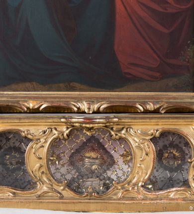 Zdjęcie nr 14: Feretron dwustronny  z obrazami świętej Anny Samotrzeć oraz św. Jana Kantego adorującego Matkę Boską  z Dzieciątkiem ustawiony na niskim postumencie o fantazyjnym kształcie z osią główną wysuniętą do przodu oraz narożnikami ustawionymi ukośnie.  W postumencie dziewięć przeszklonych gablotek mieszczących relikwie świętych, które opisane są na małych karteczkach, otoczone różnego rodzaju kwiatkami  i gwiazdkami wykonanymi z papieru i cienkich blaszek. Otwory gablotek  o różnorodnym, opływowym wykroju. Po bokach, na górnej powierzchni podstawy małe otwory po zatkniętych w nich, niezachowanych rzeźbach apostołów. Rama  w kształcie stojącego prostokąta, ujęta po każdej stronie trzema gablotkami otoczonymi rzeźbionym ornamentem rocaille'owym. W zwieńczeniu takie same, mniejsze gablotki, pośrodku zamiast relikwii ażurowa, rzeźbiona wić roślinna. Na rewersie struktura feretronu o takim samym kształcie. Podstawa zdobiona siedmioma ramkami  o fantazyjnym kształtach utworzonych z wąskich esownic. Po bokach zamiast gablotek  owoidalne pola, w których złocona, drobna kratka. Rama zdobiona ornamentem rocaille'owym.

Na awersie obraz z przedstawieniem św. Anny Samotrzeć. W centrum kompozycji ukazane są w postawie siedzącej św. Anna po prawej stronie i Matka Boska z Dzieciątkiem Jezus po lewej stronie. Maria zwrócona trzy czwarte w lewo, rękami przytrzymująca siedzące na jej kolanach Dzieciątko. Twarz owalna, z wyraźnie zaznaczonym podbródkiem, małe i jasnoróżowe usta, długi i szeroki nos, oczy lekko przymknięte, wysokie czoło. Włosy długie, falowane, z przedziałkiem pośrodku opadające na plecy i prawe ramię. Ubrana jest w długą, różową suknię ze złotym obszyciem pod szyją i na rękawach; niebieski płaszcz z brązową podszewką, zarzucony na plecy i otulający kolana oraz biały, delikatny welon  na głowie. Dzieciątko Jezus ukazane jest frontalnie, z lewą rączką uniesioną w geście błogosławieństwa. Twarz szeroka  z długim i szerokim nosem, wysokim czołem. Włosy krótkie, jasne, kędzierzawe. Wokół bioder ma założoną białą pieluszkę. Święta Anna zwrócona trzy czwarte w prawo,  z głową widoczną z lewego profilu, z lewą ręką przytrzymująca lewą rączkę Dzieciątka. Twarz podłużna z długim i szerokim nosem. Ubrana jest w długą zieloną suknię z długimi rękawami, czerwony płaszcz przerzucony  przez prawe ramię i zasłaniający kolana oraz jasnobrązową chustę zakrywającą włosy  i szyję. Karnacja ciemna. Wokół głów postaci złote, okrągłe nimby. W dolnej części obrazu widoczna roślinność, w górnej szarobłękitne niebo.

Na rewersie obraz z przedstawieniem Matki Boskiej z Dzieciątkiem adorowanych przez św. Jana Kantego. Scena zakomponowana  w architektonicznym wnętrzu. Maria ukazana w lewym górnym narożu obrazu,  w pozycji siedzącej na obłoku, zwrócona trzy czwarte w lewo, rękami przytrzymująca stojące na jej kolanach Dzieciątko. Twarz owalna z długim i wąskim nosem. Włosy długie, kręcone, ciemnobrązowe, schowane pod chustą. Ubrana w jasnoróżową suknię z długimi rękawami, niebieski płaszcz zasłaniający kolana, brązową chustę na głowie; na stopach sandały. Dzieciątko ukazane w pozycji stojącej, z lewą rączką wyciągniętą przed siebie, otulone przez Marię białą chustą na wysokości bioder. Diagonalnie, w dolnym, prawym narożu obrazu ukazany św. Jan Kanty; zwrócony trzy czwarte w prawo; z rękami wzniesionymi w geście modlitwy; z głową widoczną z lewego profilu, zwróconą w stronę Marii. Ubrany jest w togę profesorską. Twarz podłużna z długim i wąskim nosem, okolona krótko przystrzyżoną, siwą brodą. Włosy średniej długości, zwinięte w siwe pukle. Wokół głowy złoty, okrągły nimb. W dolnym narożu obrazu, na kamiennej posadzce otwarta, zapisana księga oraz zielona palma. Tło architektoniczne, po prawej stronie widoczna ostrołukowa arkada.

Relikwie umieszczone w niewielkich wnękach, za szybkami, opisane. Zwieńczenie feretronu, od lewej: relikwie „Sancti Vincentii Martyr”, relikwie „Sanctae Perpentuae Martyr”. Prawy bok feretronu, od góry: relikwie „Sancti Longina Męczennika”; relikwie  „Sanctae Kunegundy Panny”; relikwie „Mafsa SS. MM.”, „Sanctae Victorii Martyr”, „Sanctae Agnészki Panny i [...]”. Podstawa feretronu, od lewej: relikwie „Sancti Grzegorza Papieża”; relikwie „Sanctae Katarzyny”; relikwie „sanctus Clarus martyr”; relikwie „Sanctae Theogeni Martyr”; relikwie  „Sancti Urbana Papieża, Pluvium. Mino., Świętych Męczenników, Sanctae Gratii Marii”; relikwie „Sancti Theodori Martyr.”; relikwie „Sancti Jucundi Martyr”; relikwie „Iňocentii XI.”; relikwie „Sancti Jana Kapistrana”. Lewy bok feretronu, od góry: relikwie „Sancti Jana Kantego”; relikwie  „Sanctae Jadwigi Polki”; relikwie „Sanctae Pauliny Panny Męczennicy, Sancti Celestyna Papieża Męczen.,  SANCTI STANISŁAWA BISKUPA I MĘCZENNIKA”.
