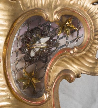 Zdjęcie nr 24: Feretron dwustronny  z obrazami świętej Anny Samotrzeć oraz św. Jana Kantego adorującego Matkę Boską  z Dzieciątkiem ustawiony na niskim postumencie o fantazyjnym kształcie z osią główną wysuniętą do przodu oraz narożnikami ustawionymi ukośnie.  W postumencie dziewięć przeszklonych gablotek mieszczących relikwie świętych, które opisane są na małych karteczkach, otoczone różnego rodzaju kwiatkami  i gwiazdkami wykonanymi z papieru i cienkich blaszek. Otwory gablotek  o różnorodnym, opływowym wykroju. Po bokach, na górnej powierzchni podstawy małe otwory po zatkniętych w nich, niezachowanych rzeźbach apostołów. Rama  w kształcie stojącego prostokąta, ujęta po każdej stronie trzema gablotkami otoczonymi rzeźbionym ornamentem rocaille&#039;owym. W zwieńczeniu takie same, mniejsze gablotki, pośrodku zamiast relikwii ażurowa, rzeźbiona wić roślinna. Na rewersie struktura feretronu o takim samym kształcie. Podstawa zdobiona siedmioma ramkami  o fantazyjnym kształtach utworzonych z wąskich esownic. Po bokach zamiast gablotek  owoidalne pola, w których złocona, drobna kratka. Rama zdobiona ornamentem rocaille&#039;owym.

Na awersie obraz z przedstawieniem św. Anny Samotrzeć. W centrum kompozycji ukazane są w postawie siedzącej św. Anna po prawej stronie i Matka Boska z Dzieciątkiem Jezus po lewej stronie. Maria zwrócona trzy czwarte w lewo, rękami przytrzymująca siedzące na jej kolanach Dzieciątko. Twarz owalna, z wyraźnie zaznaczonym podbródkiem, małe i jasnoróżowe usta, długi i szeroki nos, oczy lekko przymknięte, wysokie czoło. Włosy długie, falowane, z przedziałkiem pośrodku opadające na plecy i prawe ramię. Ubrana jest w długą, różową suknię ze złotym obszyciem pod szyją i na rękawach; niebieski płaszcz z brązową podszewką, zarzucony na plecy i otulający kolana oraz biały, delikatny welon  na głowie. Dzieciątko Jezus ukazane jest frontalnie, z lewą rączką uniesioną w geście błogosławieństwa. Twarz szeroka  z długim i szerokim nosem, wysokim czołem. Włosy krótkie, jasne, kędzierzawe. Wokół bioder ma założoną białą pieluszkę. Święta Anna zwrócona trzy czwarte w prawo,  z głową widoczną z lewego profilu, z lewą ręką przytrzymująca lewą rączkę Dzieciątka. Twarz podłużna z długim i szerokim nosem. Ubrana jest w długą zieloną suknię z długimi rękawami, czerwony płaszcz przerzucony  przez prawe ramię i zasłaniający kolana oraz jasnobrązową chustę zakrywającą włosy  i szyję. Karnacja ciemna. Wokół głów postaci złote, okrągłe nimby. W dolnej części obrazu widoczna roślinność, w górnej szarobłękitne niebo.

Na rewersie obraz z przedstawieniem Matki Boskiej z Dzieciątkiem adorowanych przez św. Jana Kantego. Scena zakomponowana  w architektonicznym wnętrzu. Maria ukazana w lewym górnym narożu obrazu,  w pozycji siedzącej na obłoku, zwrócona trzy czwarte w lewo, rękami przytrzymująca stojące na jej kolanach Dzieciątko. Twarz owalna z długim i wąskim nosem. Włosy długie, kręcone, ciemnobrązowe, schowane pod chustą. Ubrana w jasnoróżową suknię z długimi rękawami, niebieski płaszcz zasłaniający kolana, brązową chustę na głowie; na stopach sandały. Dzieciątko ukazane w pozycji stojącej, z lewą rączką wyciągniętą przed siebie, otulone przez Marię białą chustą na wysokości bioder. Diagonalnie, w dolnym, prawym narożu obrazu ukazany św. Jan Kanty; zwrócony trzy czwarte w prawo; z rękami wzniesionymi w geście modlitwy; z głową widoczną z lewego profilu, zwróconą w stronę Marii. Ubrany jest w togę profesorską. Twarz podłużna z długim i wąskim nosem, okolona krótko przystrzyżoną, siwą brodą. Włosy średniej długości, zwinięte w siwe pukle. Wokół głowy złoty, okrągły nimb. W dolnym narożu obrazu, na kamiennej posadzce otwarta, zapisana księga oraz zielona palma. Tło architektoniczne, po prawej stronie widoczna ostrołukowa arkada.

Relikwie umieszczone w niewielkich wnękach, za szybkami, opisane. Zwieńczenie feretronu, od lewej: relikwie „Sancti Vincentii Martyr”, relikwie „Sanctae Perpentuae Martyr”. Prawy bok feretronu, od góry: relikwie „Sancti Longina Męczennika”; relikwie  „Sanctae Kunegundy Panny”; relikwie „Mafsa SS. MM.”, „Sanctae Victorii Martyr”, „Sanctae Agnészki Panny i [...]”. Podstawa feretronu, od lewej: relikwie „Sancti Grzegorza Papieża”; relikwie „Sanctae Katarzyny”; relikwie „sanctus Clarus martyr”; relikwie „Sanctae Theogeni Martyr”; relikwie  „Sancti Urbana Papieża, Pluvium. Mino., Świętych Męczenników, Sanctae Gratii Marii”; relikwie „Sancti Theodori Martyr.”; relikwie „Sancti Jucundi Martyr”; relikwie „Iňocentii XI.”; relikwie „Sancti Jana Kapistrana”. Lewy bok feretronu, od góry: relikwie „Sancti Jana Kantego”; relikwie  „Sanctae Jadwigi Polki”; relikwie „Sanctae Pauliny Panny Męczennicy, Sancti Celestyna Papieża Męczen.,  SANCTI STANISŁAWA BISKUPA I MĘCZENNIKA”.
