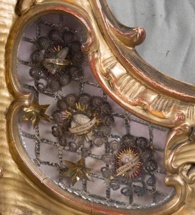 Zdjęcie nr 25: Feretron dwustronny  z obrazami świętej Anny Samotrzeć oraz św. Jana Kantego adorującego Matkę Boską  z Dzieciątkiem ustawiony na niskim postumencie o fantazyjnym kształcie z osią główną wysuniętą do przodu oraz narożnikami ustawionymi ukośnie.  W postumencie dziewięć przeszklonych gablotek mieszczących relikwie świętych, które opisane są na małych karteczkach, otoczone różnego rodzaju kwiatkami  i gwiazdkami wykonanymi z papieru i cienkich blaszek. Otwory gablotek  o różnorodnym, opływowym wykroju. Po bokach, na górnej powierzchni podstawy małe otwory po zatkniętych w nich, niezachowanych rzeźbach apostołów. Rama  w kształcie stojącego prostokąta, ujęta po każdej stronie trzema gablotkami otoczonymi rzeźbionym ornamentem rocaille&#039;owym. W zwieńczeniu takie same, mniejsze gablotki, pośrodku zamiast relikwii ażurowa, rzeźbiona wić roślinna. Na rewersie struktura feretronu o takim samym kształcie. Podstawa zdobiona siedmioma ramkami  o fantazyjnym kształtach utworzonych z wąskich esownic. Po bokach zamiast gablotek  owoidalne pola, w których złocona, drobna kratka. Rama zdobiona ornamentem rocaille&#039;owym.

Na awersie obraz z przedstawieniem św. Anny Samotrzeć. W centrum kompozycji ukazane są w postawie siedzącej św. Anna po prawej stronie i Matka Boska z Dzieciątkiem Jezus po lewej stronie. Maria zwrócona trzy czwarte w lewo, rękami przytrzymująca siedzące na jej kolanach Dzieciątko. Twarz owalna, z wyraźnie zaznaczonym podbródkiem, małe i jasnoróżowe usta, długi i szeroki nos, oczy lekko przymknięte, wysokie czoło. Włosy długie, falowane, z przedziałkiem pośrodku opadające na plecy i prawe ramię. Ubrana jest w długą, różową suknię ze złotym obszyciem pod szyją i na rękawach; niebieski płaszcz z brązową podszewką, zarzucony na plecy i otulający kolana oraz biały, delikatny welon  na głowie. Dzieciątko Jezus ukazane jest frontalnie, z lewą rączką uniesioną w geście błogosławieństwa. Twarz szeroka  z długim i szerokim nosem, wysokim czołem. Włosy krótkie, jasne, kędzierzawe. Wokół bioder ma założoną białą pieluszkę. Święta Anna zwrócona trzy czwarte w prawo,  z głową widoczną z lewego profilu, z lewą ręką przytrzymująca lewą rączkę Dzieciątka. Twarz podłużna z długim i szerokim nosem. Ubrana jest w długą zieloną suknię z długimi rękawami, czerwony płaszcz przerzucony  przez prawe ramię i zasłaniający kolana oraz jasnobrązową chustę zakrywającą włosy  i szyję. Karnacja ciemna. Wokół głów postaci złote, okrągłe nimby. W dolnej części obrazu widoczna roślinność, w górnej szarobłękitne niebo.

Na rewersie obraz z przedstawieniem Matki Boskiej z Dzieciątkiem adorowanych przez św. Jana Kantego. Scena zakomponowana  w architektonicznym wnętrzu. Maria ukazana w lewym górnym narożu obrazu,  w pozycji siedzącej na obłoku, zwrócona trzy czwarte w lewo, rękami przytrzymująca stojące na jej kolanach Dzieciątko. Twarz owalna z długim i wąskim nosem. Włosy długie, kręcone, ciemnobrązowe, schowane pod chustą. Ubrana w jasnoróżową suknię z długimi rękawami, niebieski płaszcz zasłaniający kolana, brązową chustę na głowie; na stopach sandały. Dzieciątko ukazane w pozycji stojącej, z lewą rączką wyciągniętą przed siebie, otulone przez Marię białą chustą na wysokości bioder. Diagonalnie, w dolnym, prawym narożu obrazu ukazany św. Jan Kanty; zwrócony trzy czwarte w prawo; z rękami wzniesionymi w geście modlitwy; z głową widoczną z lewego profilu, zwróconą w stronę Marii. Ubrany jest w togę profesorską. Twarz podłużna z długim i wąskim nosem, okolona krótko przystrzyżoną, siwą brodą. Włosy średniej długości, zwinięte w siwe pukle. Wokół głowy złoty, okrągły nimb. W dolnym narożu obrazu, na kamiennej posadzce otwarta, zapisana księga oraz zielona palma. Tło architektoniczne, po prawej stronie widoczna ostrołukowa arkada.

Relikwie umieszczone w niewielkich wnękach, za szybkami, opisane. Zwieńczenie feretronu, od lewej: relikwie „Sancti Vincentii Martyr”, relikwie „Sanctae Perpentuae Martyr”. Prawy bok feretronu, od góry: relikwie „Sancti Longina Męczennika”; relikwie  „Sanctae Kunegundy Panny”; relikwie „Mafsa SS. MM.”, „Sanctae Victorii Martyr”, „Sanctae Agnészki Panny i [...]”. Podstawa feretronu, od lewej: relikwie „Sancti Grzegorza Papieża”; relikwie „Sanctae Katarzyny”; relikwie „sanctus Clarus martyr”; relikwie „Sanctae Theogeni Martyr”; relikwie  „Sancti Urbana Papieża, Pluvium. Mino., Świętych Męczenników, Sanctae Gratii Marii”; relikwie „Sancti Theodori Martyr.”; relikwie „Sancti Jucundi Martyr”; relikwie „Iňocentii XI.”; relikwie „Sancti Jana Kapistrana”. Lewy bok feretronu, od góry: relikwie „Sancti Jana Kantego”; relikwie  „Sanctae Jadwigi Polki”; relikwie „Sanctae Pauliny Panny Męczennicy, Sancti Celestyna Papieża Męczen.,  SANCTI STANISŁAWA BISKUPA I MĘCZENNIKA”.
