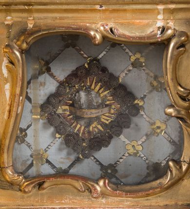 Zdjęcie nr 28: Feretron dwustronny  z obrazami świętej Anny Samotrzeć oraz św. Jana Kantego adorującego Matkę Boską  z Dzieciątkiem ustawiony na niskim postumencie o fantazyjnym kształcie z osią główną wysuniętą do przodu oraz narożnikami ustawionymi ukośnie.  W postumencie dziewięć przeszklonych gablotek mieszczących relikwie świętych, które opisane są na małych karteczkach, otoczone różnego rodzaju kwiatkami  i gwiazdkami wykonanymi z papieru i cienkich blaszek. Otwory gablotek  o różnorodnym, opływowym wykroju. Po bokach, na górnej powierzchni podstawy małe otwory po zatkniętych w nich, niezachowanych rzeźbach apostołów. Rama  w kształcie stojącego prostokąta, ujęta po każdej stronie trzema gablotkami otoczonymi rzeźbionym ornamentem rocaille'owym. W zwieńczeniu takie same, mniejsze gablotki, pośrodku zamiast relikwii ażurowa, rzeźbiona wić roślinna. Na rewersie struktura feretronu o takim samym kształcie. Podstawa zdobiona siedmioma ramkami  o fantazyjnym kształtach utworzonych z wąskich esownic. Po bokach zamiast gablotek  owoidalne pola, w których złocona, drobna kratka. Rama zdobiona ornamentem rocaille'owym.

Na awersie obraz z przedstawieniem św. Anny Samotrzeć. W centrum kompozycji ukazane są w postawie siedzącej św. Anna po prawej stronie i Matka Boska z Dzieciątkiem Jezus po lewej stronie. Maria zwrócona trzy czwarte w lewo, rękami przytrzymująca siedzące na jej kolanach Dzieciątko. Twarz owalna, z wyraźnie zaznaczonym podbródkiem, małe i jasnoróżowe usta, długi i szeroki nos, oczy lekko przymknięte, wysokie czoło. Włosy długie, falowane, z przedziałkiem pośrodku opadające na plecy i prawe ramię. Ubrana jest w długą, różową suknię ze złotym obszyciem pod szyją i na rękawach; niebieski płaszcz z brązową podszewką, zarzucony na plecy i otulający kolana oraz biały, delikatny welon  na głowie. Dzieciątko Jezus ukazane jest frontalnie, z lewą rączką uniesioną w geście błogosławieństwa. Twarz szeroka  z długim i szerokim nosem, wysokim czołem. Włosy krótkie, jasne, kędzierzawe. Wokół bioder ma założoną białą pieluszkę. Święta Anna zwrócona trzy czwarte w prawo,  z głową widoczną z lewego profilu, z lewą ręką przytrzymująca lewą rączkę Dzieciątka. Twarz podłużna z długim i szerokim nosem. Ubrana jest w długą zieloną suknię z długimi rękawami, czerwony płaszcz przerzucony  przez prawe ramię i zasłaniający kolana oraz jasnobrązową chustę zakrywającą włosy  i szyję. Karnacja ciemna. Wokół głów postaci złote, okrągłe nimby. W dolnej części obrazu widoczna roślinność, w górnej szarobłękitne niebo.

Na rewersie obraz z przedstawieniem Matki Boskiej z Dzieciątkiem adorowanych przez św. Jana Kantego. Scena zakomponowana  w architektonicznym wnętrzu. Maria ukazana w lewym górnym narożu obrazu,  w pozycji siedzącej na obłoku, zwrócona trzy czwarte w lewo, rękami przytrzymująca stojące na jej kolanach Dzieciątko. Twarz owalna z długim i wąskim nosem. Włosy długie, kręcone, ciemnobrązowe, schowane pod chustą. Ubrana w jasnoróżową suknię z długimi rękawami, niebieski płaszcz zasłaniający kolana, brązową chustę na głowie; na stopach sandały. Dzieciątko ukazane w pozycji stojącej, z lewą rączką wyciągniętą przed siebie, otulone przez Marię białą chustą na wysokości bioder. Diagonalnie, w dolnym, prawym narożu obrazu ukazany św. Jan Kanty; zwrócony trzy czwarte w prawo; z rękami wzniesionymi w geście modlitwy; z głową widoczną z lewego profilu, zwróconą w stronę Marii. Ubrany jest w togę profesorską. Twarz podłużna z długim i wąskim nosem, okolona krótko przystrzyżoną, siwą brodą. Włosy średniej długości, zwinięte w siwe pukle. Wokół głowy złoty, okrągły nimb. W dolnym narożu obrazu, na kamiennej posadzce otwarta, zapisana księga oraz zielona palma. Tło architektoniczne, po prawej stronie widoczna ostrołukowa arkada.

Relikwie umieszczone w niewielkich wnękach, za szybkami, opisane. Zwieńczenie feretronu, od lewej: relikwie „Sancti Vincentii Martyr”, relikwie „Sanctae Perpentuae Martyr”. Prawy bok feretronu, od góry: relikwie „Sancti Longina Męczennika”; relikwie  „Sanctae Kunegundy Panny”; relikwie „Mafsa SS. MM.”, „Sanctae Victorii Martyr”, „Sanctae Agnészki Panny i [...]”. Podstawa feretronu, od lewej: relikwie „Sancti Grzegorza Papieża”; relikwie „Sanctae Katarzyny”; relikwie „sanctus Clarus martyr”; relikwie „Sanctae Theogeni Martyr”; relikwie  „Sancti Urbana Papieża, Pluvium. Mino., Świętych Męczenników, Sanctae Gratii Marii”; relikwie „Sancti Theodori Martyr.”; relikwie „Sancti Jucundi Martyr”; relikwie „Iňocentii XI.”; relikwie „Sancti Jana Kapistrana”. Lewy bok feretronu, od góry: relikwie „Sancti Jana Kantego”; relikwie  „Sanctae Jadwigi Polki”; relikwie „Sanctae Pauliny Panny Męczennicy, Sancti Celestyna Papieża Męczen.,  SANCTI STANISŁAWA BISKUPA I MĘCZENNIKA”.
