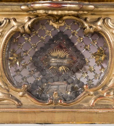 Zdjęcie nr 31: Feretron dwustronny  z obrazami świętej Anny Samotrzeć oraz św. Jana Kantego adorującego Matkę Boską  z Dzieciątkiem ustawiony na niskim postumencie o fantazyjnym kształcie z osią główną wysuniętą do przodu oraz narożnikami ustawionymi ukośnie.  W postumencie dziewięć przeszklonych gablotek mieszczących relikwie świętych, które opisane są na małych karteczkach, otoczone różnego rodzaju kwiatkami  i gwiazdkami wykonanymi z papieru i cienkich blaszek. Otwory gablotek  o różnorodnym, opływowym wykroju. Po bokach, na górnej powierzchni podstawy małe otwory po zatkniętych w nich, niezachowanych rzeźbach apostołów. Rama  w kształcie stojącego prostokąta, ujęta po każdej stronie trzema gablotkami otoczonymi rzeźbionym ornamentem rocaille'owym. W zwieńczeniu takie same, mniejsze gablotki, pośrodku zamiast relikwii ażurowa, rzeźbiona wić roślinna. Na rewersie struktura feretronu o takim samym kształcie. Podstawa zdobiona siedmioma ramkami  o fantazyjnym kształtach utworzonych z wąskich esownic. Po bokach zamiast gablotek  owoidalne pola, w których złocona, drobna kratka. Rama zdobiona ornamentem rocaille'owym.

Na awersie obraz z przedstawieniem św. Anny Samotrzeć. W centrum kompozycji ukazane są w postawie siedzącej św. Anna po prawej stronie i Matka Boska z Dzieciątkiem Jezus po lewej stronie. Maria zwrócona trzy czwarte w lewo, rękami przytrzymująca siedzące na jej kolanach Dzieciątko. Twarz owalna, z wyraźnie zaznaczonym podbródkiem, małe i jasnoróżowe usta, długi i szeroki nos, oczy lekko przymknięte, wysokie czoło. Włosy długie, falowane, z przedziałkiem pośrodku opadające na plecy i prawe ramię. Ubrana jest w długą, różową suknię ze złotym obszyciem pod szyją i na rękawach; niebieski płaszcz z brązową podszewką, zarzucony na plecy i otulający kolana oraz biały, delikatny welon  na głowie. Dzieciątko Jezus ukazane jest frontalnie, z lewą rączką uniesioną w geście błogosławieństwa. Twarz szeroka  z długim i szerokim nosem, wysokim czołem. Włosy krótkie, jasne, kędzierzawe. Wokół bioder ma założoną białą pieluszkę. Święta Anna zwrócona trzy czwarte w prawo,  z głową widoczną z lewego profilu, z lewą ręką przytrzymująca lewą rączkę Dzieciątka. Twarz podłużna z długim i szerokim nosem. Ubrana jest w długą zieloną suknię z długimi rękawami, czerwony płaszcz przerzucony  przez prawe ramię i zasłaniający kolana oraz jasnobrązową chustę zakrywającą włosy  i szyję. Karnacja ciemna. Wokół głów postaci złote, okrągłe nimby. W dolnej części obrazu widoczna roślinność, w górnej szarobłękitne niebo.

Na rewersie obraz z przedstawieniem Matki Boskiej z Dzieciątkiem adorowanych przez św. Jana Kantego. Scena zakomponowana  w architektonicznym wnętrzu. Maria ukazana w lewym górnym narożu obrazu,  w pozycji siedzącej na obłoku, zwrócona trzy czwarte w lewo, rękami przytrzymująca stojące na jej kolanach Dzieciątko. Twarz owalna z długim i wąskim nosem. Włosy długie, kręcone, ciemnobrązowe, schowane pod chustą. Ubrana w jasnoróżową suknię z długimi rękawami, niebieski płaszcz zasłaniający kolana, brązową chustę na głowie; na stopach sandały. Dzieciątko ukazane w pozycji stojącej, z lewą rączką wyciągniętą przed siebie, otulone przez Marię białą chustą na wysokości bioder. Diagonalnie, w dolnym, prawym narożu obrazu ukazany św. Jan Kanty; zwrócony trzy czwarte w prawo; z rękami wzniesionymi w geście modlitwy; z głową widoczną z lewego profilu, zwróconą w stronę Marii. Ubrany jest w togę profesorską. Twarz podłużna z długim i wąskim nosem, okolona krótko przystrzyżoną, siwą brodą. Włosy średniej długości, zwinięte w siwe pukle. Wokół głowy złoty, okrągły nimb. W dolnym narożu obrazu, na kamiennej posadzce otwarta, zapisana księga oraz zielona palma. Tło architektoniczne, po prawej stronie widoczna ostrołukowa arkada.

Relikwie umieszczone w niewielkich wnękach, za szybkami, opisane. Zwieńczenie feretronu, od lewej: relikwie „Sancti Vincentii Martyr”, relikwie „Sanctae Perpentuae Martyr”. Prawy bok feretronu, od góry: relikwie „Sancti Longina Męczennika”; relikwie  „Sanctae Kunegundy Panny”; relikwie „Mafsa SS. MM.”, „Sanctae Victorii Martyr”, „Sanctae Agnészki Panny i [...]”. Podstawa feretronu, od lewej: relikwie „Sancti Grzegorza Papieża”; relikwie „Sanctae Katarzyny”; relikwie „sanctus Clarus martyr”; relikwie „Sanctae Theogeni Martyr”; relikwie  „Sancti Urbana Papieża, Pluvium. Mino., Świętych Męczenników, Sanctae Gratii Marii”; relikwie „Sancti Theodori Martyr.”; relikwie „Sancti Jucundi Martyr”; relikwie „Iňocentii XI.”; relikwie „Sancti Jana Kapistrana”. Lewy bok feretronu, od góry: relikwie „Sancti Jana Kantego”; relikwie  „Sanctae Jadwigi Polki”; relikwie „Sanctae Pauliny Panny Męczennicy, Sancti Celestyna Papieża Męczen.,  SANCTI STANISŁAWA BISKUPA I MĘCZENNIKA”.
