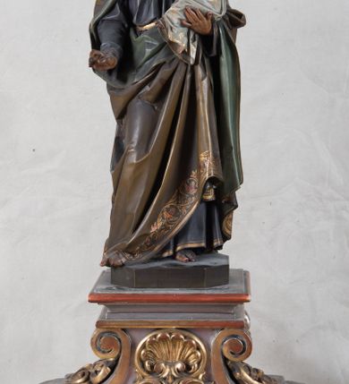 Zdjęcie nr 2: Feretron z rzeźbą św. Józefa z Dzieciątkiem ustawiony na wysokim postumencie. Postument zwężający się ku górze,  po  bokach flankowany dwiema wolutami, zaopatrzony w otwory na drążki do noszenia, stojący na czterech lwich łapkach. Na ściance frontowej zdobiony esownicami utworzonymi z liści akantu, kratką pośrodku oraz muszlą palmetową powyżej. Rzeźba ustawiona na niskim, kwadratowym, ciemnozielonym, cokole o ściętych narożach. Święty Józef ukazany w postawie stojącej, w delikatnym kontrapoście z Dzieciątkiem Jezus na lewym ręku, z prawą ręką wysuniętą przed siebie. Twarz podłużna, z długim i wąskim nosem, okolona krótko przystrzyżoną brodą; włosy brązowe, średniej długości, kręcone. Święty jest ubrany jest w ciemnofioletową suknię z długimi rękawami i ze złotą lamówką u dołu oraz przy szyi, przepasaną złotym paskiem; jasnobrązowy płaszcz z zieloną podszewką na brzegu zdobiony wicią roślinną  z owocami granatu; stopy bose. Dzieciątko Jezus ukazane w pozycji siedzącej na lewym ramieniu św. Józefa, prawą rączką obejmuje go za szyję, lewą kładzie na jego piersi. Twarz okrągła, wysokie czoło, małe usta, jasnobłękitne oczy, nos krótki i szeroki; włosy krótkie, jasne i kręcone. Dzieciątko jest ubrane w białą, długą sukienkę  z długimi rękawami, ze złotym obszyciem na brzegach, zdobioną malowanymi, złotymi małymi krzyżykami. Struktura postumentu polichromowana w kolorze jasnoszarym, detale  i ornamentyka złocone.
