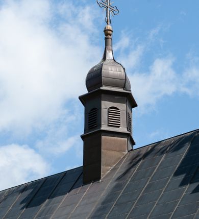 Zdjęcie nr 13: Kościół Niepokalanego Serca Najświętszej Marii Panny w Hucisku usytuowany jest w południowo-zachodniej części wsi. Plac przykościelny otoczony jest żeliwnym płotem z murowanymi słupkami. Kościół skierowany jest na zachód, murowany, otynkowany z wieżą od wschodu. Wnętrze świątyni tworzy niewielkie, prostokątne, prezbiterium zakończone trójbocznie. Nawa jest szersza, na planie prostokąta, nakryta stropem, oddzielona od prezbiterium szeroką, półkoliście zamkniętą arkadą w ścianie tęczowej. Od południa do prezbiterium przylega założona na planie prostokąta niewielka zakrystia. Na wschodniej ścianie kościoła drewniany chór muzyczny, wsparty na dwóch filarach jest dostępny schodami od południowej strony nawy. Nawę oświetlają umieszczone w północnych i południowych ścianach prostokątne, zamknięte półkoliście okna, po trzy z każdej strony. Do świątyni prowadzą dwa wejścia: główne od strony wschodniej, drugie przez zakrystię. Wejście główne prowadzi poprzez dwuskrzydłowe drzwi z kruchty pod wieżą. 

W zewnętrznej elewacji kościoła widoczny jest niewysoki, kamienny cokół, wykonany z regularnych ciosów kamienia. Prezbiterium jest niższe od nawy. Do wschodniej fasady kościoła dostawiono założoną na planie kwadratu dwukondygnacyjną wieżę-dzwonnicę, ustawioną na kruchcie na planie prostokąta. Kruchta została zamknięta trójkątnym szczytem; w jej polu znajduje się głęboka wnęka w kształcie stojącego prostokąta, zamknięta łukiem półkolistym. Poszczególne kondygnacje wieży rozdzielone są daszkami i przeprute otworami okiennymi. Całość zwieńczono wieloboczną latarnią oraz cebulastym hełmem z łacińskim krzyżem. Prezbiterium i nawa przykryte są oddzielnie, stromymi dachami dwuspadowymi. Na środku nawy znajduje się wieżyczka na sygnaturkę z latarnią i cebulastym hełmem. 