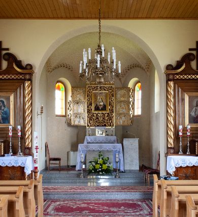 Zdjęcie nr 15: Kościół Niepokalanego Serca Najświętszej Marii Panny w Hucisku usytuowany jest w południowo-zachodniej części wsi. Plac przykościelny otoczony jest żeliwnym płotem z murowanymi słupkami. Kościół skierowany jest na zachód, murowany, otynkowany z wieżą od wschodu. Wnętrze świątyni tworzy niewielkie, prostokątne, prezbiterium zakończone trójbocznie. Nawa jest szersza, na planie prostokąta, nakryta stropem, oddzielona od prezbiterium szeroką, półkoliście zamkniętą arkadą w ścianie tęczowej. Od południa do prezbiterium przylega założona na planie prostokąta niewielka zakrystia. Na wschodniej ścianie kościoła drewniany chór muzyczny, wsparty na dwóch filarach jest dostępny schodami od południowej strony nawy. Nawę oświetlają umieszczone w północnych i południowych ścianach prostokątne, zamknięte półkoliście okna, po trzy z każdej strony. Do świątyni prowadzą dwa wejścia: główne od strony wschodniej, drugie przez zakrystię. Wejście główne prowadzi poprzez dwuskrzydłowe drzwi z kruchty pod wieżą. 

W zewnętrznej elewacji kościoła widoczny jest niewysoki, kamienny cokół, wykonany z regularnych ciosów kamienia. Prezbiterium jest niższe od nawy. Do wschodniej fasady kościoła dostawiono założoną na planie kwadratu dwukondygnacyjną wieżę-dzwonnicę, ustawioną na kruchcie na planie prostokąta. Kruchta została zamknięta trójkątnym szczytem; w jej polu znajduje się głęboka wnęka w kształcie stojącego prostokąta, zamknięta łukiem półkolistym. Poszczególne kondygnacje wieży rozdzielone są daszkami i przeprute otworami okiennymi. Całość zwieńczono wieloboczną latarnią oraz cebulastym hełmem z łacińskim krzyżem. Prezbiterium i nawa przykryte są oddzielnie, stromymi dachami dwuspadowymi. Na środku nawy znajduje się wieżyczka na sygnaturkę z latarnią i cebulastym hełmem. 