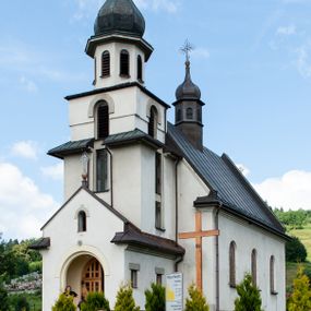 Zdjęcie nr 1: Kościół Niepokalanego Serca Najświętszej Marii Panny w Hucisku usytuowany jest w południowo-zachodniej części wsi. Plac przykościelny otoczony jest żeliwnym płotem z murowanymi słupkami. Kościół skierowany jest na zachód, murowany, otynkowany z wieżą od wschodu. Wnętrze świątyni tworzy niewielkie, prostokątne, prezbiterium zakończone trójbocznie. Nawa jest szersza, na planie prostokąta, nakryta stropem, oddzielona od prezbiterium szeroką, półkoliście zamkniętą arkadą w ścianie tęczowej. Od południa do prezbiterium przylega założona na planie prostokąta niewielka zakrystia. Na wschodniej ścianie kościoła drewniany chór muzyczny, wsparty na dwóch filarach jest dostępny schodami od południowej strony nawy. Nawę oświetlają umieszczone w północnych i południowych ścianach prostokątne, zamknięte półkoliście okna, po trzy z każdej strony. Do świątyni prowadzą dwa wejścia: główne od strony wschodniej, drugie przez zakrystię. Wejście główne prowadzi poprzez dwuskrzydłowe drzwi z kruchty pod wieżą. 

W zewnętrznej elewacji kościoła widoczny jest niewysoki, kamienny cokół, wykonany z regularnych ciosów kamienia. Prezbiterium jest niższe od nawy. Do wschodniej fasady kościoła dostawiono założoną na planie kwadratu dwukondygnacyjną wieżę-dzwonnicę, ustawioną na kruchcie na planie prostokąta. Kruchta została zamknięta trójkątnym szczytem; w jej polu znajduje się głęboka wnęka w kształcie stojącego prostokąta, zamknięta łukiem półkolistym. Poszczególne kondygnacje wieży rozdzielone są daszkami i przeprute otworami okiennymi. Całość zwieńczono wieloboczną latarnią oraz cebulastym hełmem z łacińskim krzyżem. Prezbiterium i nawa przykryte są oddzielnie, stromymi dachami dwuspadowymi. Na środku nawy znajduje się wieżyczka na sygnaturkę z latarnią i cebulastym hełmem. 