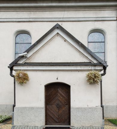 Zdjęcie nr 5: Kościół usytuowany jest w centrum miejscowości. Na plac kościelny prowadzi główne wejście od strony zachodniej oraz dwa mniejsze od strony północnej i południowej. Świątynia założona jest na planie krzyża łacińskiego, prezbiterium skierowane na zachód, równe szerokości nawy. Do korpusu kościoła przylega od strony zachodniej niższa i węższa zakrystia, a od strony południowej kruchta. Główne wejście do kościoła znajduje się od strony wschodniej przez czworoboczny przedsionek, nad którym wznosi się wieża. Portal z piaskowca, prosty o uszatych górnych narożach, w kluczu insygnia papieskie. W przedsionku od północnej strony zbudowane wewnętrzne, dwubiegowe schody kamienne prowadzące pierwotnie na chór muzyczny i wyższe piętra wieży. Na piętrze wejście do dwóch pomieszczeń usytuowanych na zapleczu chóru. Pomieszczenia te są nakryte stropami, oświetlone od południa i od wschodu. W pomieszczeniu południowym znajduje się kamienny próg z datą „1767”. Do przedsionka od strony południowej przylega kaplica Matki Boskiej Różańcowej założona na rzucie kwadratu, nakryta płaskim, malowanym stropem, wejście do kaplicy od strony północnej.

Wnętrze jest oświetlone przez 16 podłużnych okien, 8 w transepcie i 8 w ścianach nawy. Ponadto są jeszcze cztery okna okratowane, umieszczone jedno nad drugim po dwa w ścianie północnej i południowej.
Zakrystia jednoizbowa, dwa okna prostokątne w ścianie północno-zachodniej oraz dwoje drzwi, jedne do prezbiterium, drugie wejściowe w ścianie południowej. Wewnątrz zakrystii wąskie schody prowadzące do schowka na pięterku: jednoizbowego, oświetlonego od południa i od zachodu. Zakrystia i schowek nakryte płaskimi sufitami. Kruchta przybudowana do południowej ściany kościoła założona na rzucie kwadratu, o dwóch wejściach: z nawy i od zewnątrz od strony południowej. Wnętrze kościoła bez zaznaczonych podziałów architektonicznych, w dolnej części drewniana boazeria, w górnej iluzjonistyczna polichromia imitująca pilastry wspierające strop. Chór muzyczny wsparty na dwóch słupach.

Elewacja kościoła bez podziałów architektonicznych z zaznaczonym jedynie profilowanym gzymsem podokapowym. Fasada wschodnia trójosiowa ze środkowym ryzalitem, wieża włączona w korpus kościoła. W drugiej kondygnacji spływy flankujące wieżę, zakończone masywnymi sterczynami. Wieża nakryta dachem namiotowym z hełmem, na szczycie iglica. Na środku nawy ażurowa wieżyczka na sygnaturkę, nakryta daszkiem namiotowym z hełmem. Dach nad korpusem kościoła i zakrystią jednokalenicowy, dwuspadowy, nad prezbiterium i transeptem trójspadowy, nad kruchtą siodłowy.



