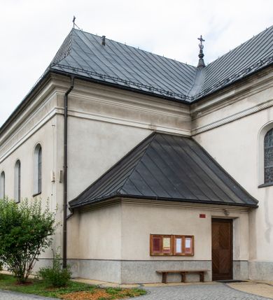Zdjęcie nr 10: Kościół usytuowany jest w centrum miejscowości. Na plac kościelny prowadzi główne wejście od strony zachodniej oraz dwa mniejsze od strony północnej i południowej. Świątynia założona jest na planie krzyża łacińskiego, prezbiterium skierowane na zachód, równe szerokości nawy. Do korpusu kościoła przylega od strony zachodniej niższa i węższa zakrystia, a od strony południowej kruchta. Główne wejście do kościoła znajduje się od strony wschodniej przez czworoboczny przedsionek, nad którym wznosi się wieża. Portal z piaskowca, prosty o uszatych górnych narożach, w kluczu insygnia papieskie. W przedsionku od północnej strony zbudowane wewnętrzne, dwubiegowe schody kamienne prowadzące pierwotnie na chór muzyczny i wyższe piętra wieży. Na piętrze wejście do dwóch pomieszczeń usytuowanych na zapleczu chóru. Pomieszczenia te są nakryte stropami, oświetlone od południa i od wschodu. W pomieszczeniu południowym znajduje się kamienny próg z datą „1767”. Do przedsionka od strony południowej przylega kaplica Matki Boskiej Różańcowej założona na rzucie kwadratu, nakryta płaskim, malowanym stropem, wejście do kaplicy od strony północnej.

Wnętrze jest oświetlone przez 16 podłużnych okien, 8 w transepcie i 8 w ścianach nawy. Ponadto są jeszcze cztery okna okratowane, umieszczone jedno nad drugim po dwa w ścianie północnej i południowej.
Zakrystia jednoizbowa, dwa okna prostokątne w ścianie północno-zachodniej oraz dwoje drzwi, jedne do prezbiterium, drugie wejściowe w ścianie południowej. Wewnątrz zakrystii wąskie schody prowadzące do schowka na pięterku: jednoizbowego, oświetlonego od południa i od zachodu. Zakrystia i schowek nakryte płaskimi sufitami. Kruchta przybudowana do południowej ściany kościoła założona na rzucie kwadratu, o dwóch wejściach: z nawy i od zewnątrz od strony południowej. Wnętrze kościoła bez zaznaczonych podziałów architektonicznych, w dolnej części drewniana boazeria, w górnej iluzjonistyczna polichromia imitująca pilastry wspierające strop. Chór muzyczny wsparty na dwóch słupach.

Elewacja kościoła bez podziałów architektonicznych z zaznaczonym jedynie profilowanym gzymsem podokapowym. Fasada wschodnia trójosiowa ze środkowym ryzalitem, wieża włączona w korpus kościoła. W drugiej kondygnacji spływy flankujące wieżę, zakończone masywnymi sterczynami. Wieża nakryta dachem namiotowym z hełmem, na szczycie iglica. Na środku nawy ażurowa wieżyczka na sygnaturkę, nakryta daszkiem namiotowym z hełmem. Dach nad korpusem kościoła i zakrystią jednokalenicowy, dwuspadowy, nad prezbiterium i transeptem trójspadowy, nad kruchtą siodłowy.



