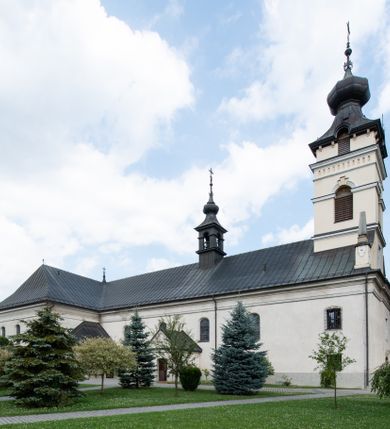 Zdjęcie nr 3: Kościół usytuowany jest w centrum miejscowości. Na plac kościelny prowadzi główne wejście od strony zachodniej oraz dwa mniejsze od strony północnej i południowej. Świątynia założona jest na planie krzyża łacińskiego, prezbiterium skierowane na zachód, równe szerokości nawy. Do korpusu kościoła przylega od strony zachodniej niższa i węższa zakrystia, a od strony południowej kruchta. Główne wejście do kościoła znajduje się od strony wschodniej przez czworoboczny przedsionek, nad którym wznosi się wieża. Portal z piaskowca, prosty o uszatych górnych narożach, w kluczu insygnia papieskie. W przedsionku od północnej strony zbudowane wewnętrzne, dwubiegowe schody kamienne prowadzące pierwotnie na chór muzyczny i wyższe piętra wieży. Na piętrze wejście do dwóch pomieszczeń usytuowanych na zapleczu chóru. Pomieszczenia te są nakryte stropami, oświetlone od południa i od wschodu. W pomieszczeniu południowym znajduje się kamienny próg z datą „1767”. Do przedsionka od strony południowej przylega kaplica Matki Boskiej Różańcowej założona na rzucie kwadratu, nakryta płaskim, malowanym stropem, wejście do kaplicy od strony północnej.

Wnętrze jest oświetlone przez 16 podłużnych okien, 8 w transepcie i 8 w ścianach nawy. Ponadto są jeszcze cztery okna okratowane, umieszczone jedno nad drugim po dwa w ścianie północnej i południowej.
Zakrystia jednoizbowa, dwa okna prostokątne w ścianie północno-zachodniej oraz dwoje drzwi, jedne do prezbiterium, drugie wejściowe w ścianie południowej. Wewnątrz zakrystii wąskie schody prowadzące do schowka na pięterku: jednoizbowego, oświetlonego od południa i od zachodu. Zakrystia i schowek nakryte płaskimi sufitami. Kruchta przybudowana do południowej ściany kościoła założona na rzucie kwadratu, o dwóch wejściach: z nawy i od zewnątrz od strony południowej. Wnętrze kościoła bez zaznaczonych podziałów architektonicznych, w dolnej części drewniana boazeria, w górnej iluzjonistyczna polichromia imitująca pilastry wspierające strop. Chór muzyczny wsparty na dwóch słupach.

Elewacja kościoła bez podziałów architektonicznych z zaznaczonym jedynie profilowanym gzymsem podokapowym. Fasada wschodnia trójosiowa ze środkowym ryzalitem, wieża włączona w korpus kościoła. W drugiej kondygnacji spływy flankujące wieżę, zakończone masywnymi sterczynami. Wieża nakryta dachem namiotowym z hełmem, na szczycie iglica. Na środku nawy ażurowa wieżyczka na sygnaturkę, nakryta daszkiem namiotowym z hełmem. Dach nad korpusem kościoła i zakrystią jednokalenicowy, dwuspadowy, nad prezbiterium i transeptem trójspadowy, nad kruchtą siodłowy.



