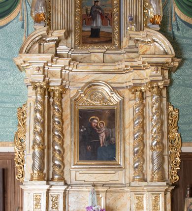 Zdjęcie nr 2: Nastawa ołtarzowa architektoniczna, dwukondygnacyjna, jednoosiowa. Ołtarz prostopadłościenny, drewniany, mensa drewniana z kamiennym portatylem. Antependium zdobione trzema prostokątnymi płycinami, zewnętrze zdobione liśćmi akantu, wewnętrza z godłem zakonu franciszkanów umieszczonym w medalionie.

Nastawa ustawiona na zdwojonym cokole, dekorowanym płycinami, wypełnionymi liśćmi akantu. Pierwsza kondygnacja flankowana pilastrami oraz ustawionymi na skraju filarami, przed nimi dwie pary kolumn, z których zewnętrzna wysunięta jest do przodu. Podpory wspierają wyłamane belkowanie i przerywany przyczółek. Trzony pilastrów i filarów kanelowane, trzony kolumn skręcone i oplecione wicią roślinną, kapitele kolumn kompozytowe. W polu głównym umieszczony jest obraz św. Antoniego Dzieciątkiem w ramie w kształcie stojącego prostokąta, zamkniętego łukiem wklęsło-wypukłym z uskokami. Nad obrazem płaskorzeźbiony wieniec chwały, dwie gałązki i sygle „S[WIĘTY] A[NTONI]”. Druga kondygnacja ujęta parą zdwojonych pilastrów. Podpory wspierają wyłamane belkowanie. W polu głównym obraz w kształcie stojącego prostokąta z przedstawieniem św. Jana Nepomucena. Trzony pilastrów kanelowane. Na szczycie umieszczona jest promienista gloria Okiem Opatrzności na tle obłoków. Po bokach zwieńczenia na wysokich cokołach figury św. Wojciecha po lewej stroni i św. Stanisława po prawej. Boki obu kondygnacji zdobione są ażurowymi uszami z liśćmi akantu. Struktura marmoryzowana w odcieniu jasnobeżowym z brązowym i czerwonym żyłkowaniem; ornamentyka, kolumny i profilowania złocone, detale srebrzone.
