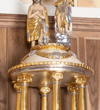 Zdjęcie nr 3: Chrzcielnica ustawiona na dwóch stopniach na rzucie półkolistym, wsparta na ośmiobocznej stopie z napisem „HOC BAPTISTERIUM EST CONSTRUCTUM MDCXXXVIII ”. Trzon ośmioboczny z ośmiobocznym pierścieniem pośrodku, ozdobionym rozetkami. Czara wysoka, ośmioboczna, zdobiona od dołu rzeźbionym ząbkowym pasem dekoracyjnym, powyżej stylizowanymi liliami andegaweńskimi, a od góry pasem liści. Pokrywa w formie małej aediculi, wsparta na sześciu kolumnach, które unoszą półkolistą kopułę. Podpory o gładkich i złoconych trzonach, kapitele jońskie. Zwieńczenie o profilowanym gzymsie, kopuła zdobiona girlandami, a na szczycie kimationem. Na kopule ustawiona grupa rzeźbiarska przedstawiająca św. Jana Chrzciciela i Chrystusa. Polichromia w odsłoniętych partiach ciała naturalistyczna, detale i ornamentyka złocone i srebrzone, kopuła polichromowana na kolor jasnobeżowy.

