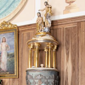 Zdjęcie nr 1: Chrzcielnica ustawiona na dwóch stopniach na rzucie półkolistym, wsparta na ośmiobocznej stopie z napisem „HOC BAPTISTERIUM EST CONSTRUCTUM MDCXXXVIII ”. Trzon ośmioboczny z ośmiobocznym pierścieniem pośrodku, ozdobionym rozetkami. Czara wysoka, ośmioboczna, zdobiona od dołu rzeźbionym ząbkowym pasem dekoracyjnym, powyżej stylizowanymi liliami andegaweńskimi, a od góry pasem liści. Pokrywa w formie małej aediculi, wsparta na sześciu kolumnach, które unoszą półkolistą kopułę. Podpory o gładkich i złoconych trzonach, kapitele jońskie. Zwieńczenie o profilowanym gzymsie, kopuła zdobiona girlandami, a na szczycie kimationem. Na kopule ustawiona grupa rzeźbiarska przedstawiająca św. Jana Chrzciciela i Chrystusa. Polichromia w odsłoniętych partiach ciała naturalistyczna, detale i ornamentyka złocone i srebrzone, kopuła polichromowana na kolor jasnobeżowy.

