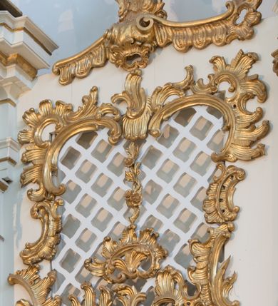 Zdjęcie nr 52: Nastawa architektoniczna, trójosiowa, dwukondygnacyjna ze zwieńczeniem, ustawiona na dwustrefowym cokole. Ołtarz drewniany, prostopadłościenny z drewnianą mensą, w partii antepedium dekorowany trzema płycinami. Na ołtarzu ustawione tabernakulum. Cokół dwustrefowy z wyodrębnionymi prostopadłościanami dekorowanymi w pierwszej strefie płycinami, w drugiej rocaille'owymi płycinami.  Osie pierwszej kondygnacji wydzielone trzema parami kolumn. Oś środkowa flankowana dwiema parami pilastrów i stojącymi przed nimi kolumnami ustawionymi na cokołach, druga para zwrócona pod kątem na zewnątrz. Podpory dźwigają wyłamane na ich osi fragmenty belkowania, środkowa para również przerwany, falisty przyczółek. Na belkowaniu i przyczółku siedzi para puttów i para adorujących aniołów. Pomiędzy parami kolumn ustawione figury św. Anny i św. Elżbiety. W polu głównym znajduje się wnęka w formie stojącego prostokąta zamkniętego łukiem półkolistym nadwieszonym z uskokiem, ujęta profilowaną ramą z obrazem Matki Boskiej z Dzieciątkiem i św. Janem Chrzcicielem. Ponad obrazem rokokowy kartusz z kwiatowymi zwisami, z napisem „EN! / PORTA PATET CURIAE / DEI EXCELSA MATER ET / VIRGO IO! VENITE / S(anctus) Cyprianus”. Osie boczne wydzielone zewnętrzną parą pilastrów i stojących przed nimi kolumn ustawionych na dwustrefowych cokołach, dźwigających imposty i fragmenty przerwanego rocaille'owego przyczółka. Na osiach w partii cokołu znajdują się bramki z drzwiami w kształcie stojącego prostokąta zamkniętego łukiem półkolistym. Ponad nimi na rocaille'owych konsolach, na tle wnęki ujętej rocaille'ową ramą znajdują się figury św. Joachima i Zachariasza. Nad wnękami ażurowa kratka w formie stojącego prostokąta ujęta rocaille'ową ramą. Całość zamknięta rocaille'm z wyodrębnionym pionowym akcentem koguciego grzebienia. Druga kondygnacja flankowana dwiema parami pilastrów, w tym zewnętrzną ustawioną pod kątem na zewnątrz o trzonach przechodzących w spływy wolutowe ustawione na cokołach na belkowaniu pierwszej kondygnacji nastawy. Spływy zakończone są rokokowymi wazonami. Podpory dźwigają gzyms przerwany na polem. Całość zamknięta medalionem z Okiem Opatrzności otoczonym wieńcem z obłoków i uskrzydlonych główek anielskich, w glorii promienistej. U dołu medalionu i na gzymsie znajdują się putta. W polu wnęka w formie stojącego prostokąta zamkniętego łukiem półkolistym nadwieszonym w profilowanej ramie z obrazem św. Kazimierza. Struktura niemal w całości polichromowana w kolorze białym, trzony kolumn polichromowane na sposób imitujący marmoryzację w kolorze biało-różowym, profile i ornamentyka złocone. 