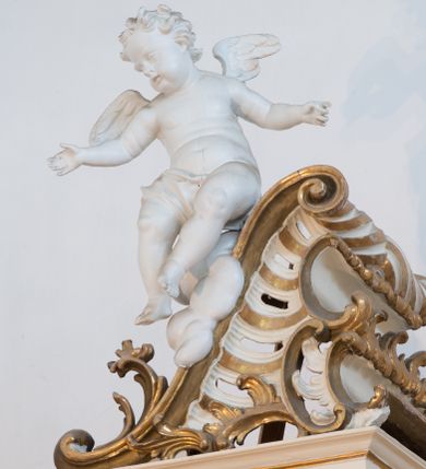 Zdjęcie nr 66: Nastawa architektoniczna, trójosiowa, dwukondygnacyjna ze zwieńczeniem, ustawiona na dwustrefowym cokole. Ołtarz drewniany, prostopadłościenny z drewnianą mensą, w partii antepedium dekorowany trzema płycinami. Na ołtarzu ustawione tabernakulum. Cokół dwustrefowy z wyodrębnionymi prostopadłościanami dekorowanymi w pierwszej strefie płycinami, w drugiej rocaille'owymi płycinami.  Osie pierwszej kondygnacji wydzielone trzema parami kolumn. Oś środkowa flankowana dwiema parami pilastrów i stojącymi przed nimi kolumnami ustawionymi na cokołach, druga para zwrócona pod kątem na zewnątrz. Podpory dźwigają wyłamane na ich osi fragmenty belkowania, środkowa para również przerwany, falisty przyczółek. Na belkowaniu i przyczółku siedzi para puttów i para adorujących aniołów. Pomiędzy parami kolumn ustawione figury św. Anny i św. Elżbiety. W polu głównym znajduje się wnęka w formie stojącego prostokąta zamkniętego łukiem półkolistym nadwieszonym z uskokiem, ujęta profilowaną ramą z obrazem Matki Boskiej z Dzieciątkiem i św. Janem Chrzcicielem. Ponad obrazem rokokowy kartusz z kwiatowymi zwisami, z napisem „EN! / PORTA PATET CURIAE / DEI EXCELSA MATER ET / VIRGO IO! VENITE / S(anctus) Cyprianus”. Osie boczne wydzielone zewnętrzną parą pilastrów i stojących przed nimi kolumn ustawionych na dwustrefowych cokołach, dźwigających imposty i fragmenty przerwanego rocaille'owego przyczółka. Na osiach w partii cokołu znajdują się bramki z drzwiami w kształcie stojącego prostokąta zamkniętego łukiem półkolistym. Ponad nimi na rocaille'owych konsolach, na tle wnęki ujętej rocaille'ową ramą znajdują się figury św. Joachima i Zachariasza. Nad wnękami ażurowa kratka w formie stojącego prostokąta ujęta rocaille'ową ramą. Całość zamknięta rocaille'm z wyodrębnionym pionowym akcentem koguciego grzebienia. Druga kondygnacja flankowana dwiema parami pilastrów, w tym zewnętrzną ustawioną pod kątem na zewnątrz o trzonach przechodzących w spływy wolutowe ustawione na cokołach na belkowaniu pierwszej kondygnacji nastawy. Spływy zakończone są rokokowymi wazonami. Podpory dźwigają gzyms przerwany na polem. Całość zamknięta medalionem z Okiem Opatrzności otoczonym wieńcem z obłoków i uskrzydlonych główek anielskich, w glorii promienistej. U dołu medalionu i na gzymsie znajdują się putta. W polu wnęka w formie stojącego prostokąta zamkniętego łukiem półkolistym nadwieszonym w profilowanej ramie z obrazem św. Kazimierza. Struktura niemal w całości polichromowana w kolorze białym, trzony kolumn polichromowane na sposób imitujący marmoryzację w kolorze biało-różowym, profile i ornamentyka złocone. 