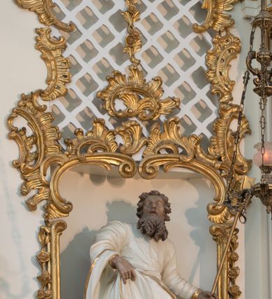 Zdjęcie nr 53: Nastawa architektoniczna, trójosiowa, dwukondygnacyjna ze zwieńczeniem, ustawiona na dwustrefowym cokole. Ołtarz drewniany, prostopadłościenny z drewnianą mensą, w partii antepedium dekorowany trzema płycinami. Na ołtarzu ustawione tabernakulum. Cokół dwustrefowy z wyodrębnionymi prostopadłościanami dekorowanymi w pierwszej strefie płycinami, w drugiej rocaille'owymi płycinami.  Osie pierwszej kondygnacji wydzielone trzema parami kolumn. Oś środkowa flankowana dwiema parami pilastrów i stojącymi przed nimi kolumnami ustawionymi na cokołach, druga para zwrócona pod kątem na zewnątrz. Podpory dźwigają wyłamane na ich osi fragmenty belkowania, środkowa para również przerwany, falisty przyczółek. Na belkowaniu i przyczółku siedzi para puttów i para adorujących aniołów. Pomiędzy parami kolumn ustawione figury św. Anny i św. Elżbiety. W polu głównym znajduje się wnęka w formie stojącego prostokąta zamkniętego łukiem półkolistym nadwieszonym z uskokiem, ujęta profilowaną ramą z obrazem Matki Boskiej z Dzieciątkiem i św. Janem Chrzcicielem. Ponad obrazem rokokowy kartusz z kwiatowymi zwisami, z napisem „EN! / PORTA PATET CURIAE / DEI EXCELSA MATER ET / VIRGO IO! VENITE / S(anctus) Cyprianus”. Osie boczne wydzielone zewnętrzną parą pilastrów i stojących przed nimi kolumn ustawionych na dwustrefowych cokołach, dźwigających imposty i fragmenty przerwanego rocaille'owego przyczółka. Na osiach w partii cokołu znajdują się bramki z drzwiami w kształcie stojącego prostokąta zamkniętego łukiem półkolistym. Ponad nimi na rocaille'owych konsolach, na tle wnęki ujętej rocaille'ową ramą znajdują się figury św. Joachima i Zachariasza. Nad wnękami ażurowa kratka w formie stojącego prostokąta ujęta rocaille'ową ramą. Całość zamknięta rocaille'm z wyodrębnionym pionowym akcentem koguciego grzebienia. Druga kondygnacja flankowana dwiema parami pilastrów, w tym zewnętrzną ustawioną pod kątem na zewnątrz o trzonach przechodzących w spływy wolutowe ustawione na cokołach na belkowaniu pierwszej kondygnacji nastawy. Spływy zakończone są rokokowymi wazonami. Podpory dźwigają gzyms przerwany na polem. Całość zamknięta medalionem z Okiem Opatrzności otoczonym wieńcem z obłoków i uskrzydlonych główek anielskich, w glorii promienistej. U dołu medalionu i na gzymsie znajdują się putta. W polu wnęka w formie stojącego prostokąta zamkniętego łukiem półkolistym nadwieszonym w profilowanej ramie z obrazem św. Kazimierza. Struktura niemal w całości polichromowana w kolorze białym, trzony kolumn polichromowane na sposób imitujący marmoryzację w kolorze biało-różowym, profile i ornamentyka złocone. 