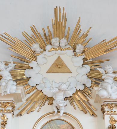 Zdjęcie nr 62: Nastawa architektoniczna, trójosiowa, dwukondygnacyjna ze zwieńczeniem, ustawiona na dwustrefowym cokole. Ołtarz drewniany, prostopadłościenny z drewnianą mensą, w partii antepedium dekorowany trzema płycinami. Na ołtarzu ustawione tabernakulum. Cokół dwustrefowy z wyodrębnionymi prostopadłościanami dekorowanymi w pierwszej strefie płycinami, w drugiej rocaille&#039;owymi płycinami.  Osie pierwszej kondygnacji wydzielone trzema parami kolumn. Oś środkowa flankowana dwiema parami pilastrów i stojącymi przed nimi kolumnami ustawionymi na cokołach, druga para zwrócona pod kątem na zewnątrz. Podpory dźwigają wyłamane na ich osi fragmenty belkowania, środkowa para również przerwany, falisty przyczółek. Na belkowaniu i przyczółku siedzi para puttów i para adorujących aniołów. Pomiędzy parami kolumn ustawione figury św. Anny i św. Elżbiety. W polu głównym znajduje się wnęka w formie stojącego prostokąta zamkniętego łukiem półkolistym nadwieszonym z uskokiem, ujęta profilowaną ramą z obrazem Matki Boskiej z Dzieciątkiem i św. Janem Chrzcicielem. Ponad obrazem rokokowy kartusz z kwiatowymi zwisami, z napisem „EN! / PORTA PATET CURIAE / DEI EXCELSA MATER ET / VIRGO IO! VENITE / S(anctus) Cyprianus”. Osie boczne wydzielone zewnętrzną parą pilastrów i stojących przed nimi kolumn ustawionych na dwustrefowych cokołach, dźwigających imposty i fragmenty przerwanego rocaille&#039;owego przyczółka. Na osiach w partii cokołu znajdują się bramki z drzwiami w kształcie stojącego prostokąta zamkniętego łukiem półkolistym. Ponad nimi na rocaille&#039;owych konsolach, na tle wnęki ujętej rocaille&#039;ową ramą znajdują się figury św. Joachima i Zachariasza. Nad wnękami ażurowa kratka w formie stojącego prostokąta ujęta rocaille&#039;ową ramą. Całość zamknięta rocaille&#039;m z wyodrębnionym pionowym akcentem koguciego grzebienia. Druga kondygnacja flankowana dwiema parami pilastrów, w tym zewnętrzną ustawioną pod kątem na zewnątrz o trzonach przechodzących w spływy wolutowe ustawione na cokołach na belkowaniu pierwszej kondygnacji nastawy. Spływy zakończone są rokokowymi wazonami. Podpory dźwigają gzyms przerwany na polem. Całość zamknięta medalionem z Okiem Opatrzności otoczonym wieńcem z obłoków i uskrzydlonych główek anielskich, w glorii promienistej. U dołu medalionu i na gzymsie znajdują się putta. W polu wnęka w formie stojącego prostokąta zamkniętego łukiem półkolistym nadwieszonym w profilowanej ramie z obrazem św. Kazimierza. Struktura niemal w całości polichromowana w kolorze białym, trzony kolumn polichromowane na sposób imitujący marmoryzację w kolorze biało-różowym, profile i ornamentyka złocone. 