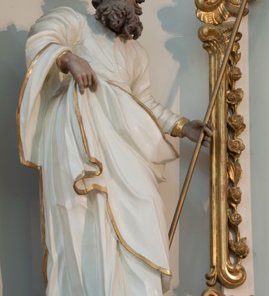 Zdjęcie nr 20: Nastawa architektoniczna, trójosiowa, dwukondygnacyjna ze zwieńczeniem, ustawiona na dwustrefowym cokole. Ołtarz drewniany, prostopadłościenny z drewnianą mensą, w partii antepedium dekorowany trzema płycinami. Na ołtarzu ustawione tabernakulum. Cokół dwustrefowy z wyodrębnionymi prostopadłościanami dekorowanymi w pierwszej strefie płycinami, w drugiej rocaille'owymi płycinami.  Osie pierwszej kondygnacji wydzielone trzema parami kolumn. Oś środkowa flankowana dwiema parami pilastrów i stojącymi przed nimi kolumnami ustawionymi na cokołach, druga para zwrócona pod kątem na zewnątrz. Podpory dźwigają wyłamane na ich osi fragmenty belkowania, środkowa para również przerwany, falisty przyczółek. Na belkowaniu i przyczółku siedzi para puttów i para adorujących aniołów. Pomiędzy parami kolumn ustawione figury św. Anny i św. Elżbiety. W polu głównym znajduje się wnęka w formie stojącego prostokąta zamkniętego łukiem półkolistym nadwieszonym z uskokiem, ujęta profilowaną ramą z obrazem Matki Boskiej z Dzieciątkiem i św. Janem Chrzcicielem. Ponad obrazem rokokowy kartusz z kwiatowymi zwisami, z napisem „EN! / PORTA PATET CURIAE / DEI EXCELSA MATER ET / VIRGO IO! VENITE / S(anctus) Cyprianus”. Osie boczne wydzielone zewnętrzną parą pilastrów i stojących przed nimi kolumn ustawionych na dwustrefowych cokołach, dźwigających imposty i fragmenty przerwanego rocaille'owego przyczółka. Na osiach w partii cokołu znajdują się bramki z drzwiami w kształcie stojącego prostokąta zamkniętego łukiem półkolistym. Ponad nimi na rocaille'owych konsolach, na tle wnęki ujętej rocaille'ową ramą znajdują się figury św. Joachima i Zachariasza. Nad wnękami ażurowa kratka w formie stojącego prostokąta ujęta rocaille'ową ramą. Całość zamknięta rocaille'm z wyodrębnionym pionowym akcentem koguciego grzebienia. Druga kondygnacja flankowana dwiema parami pilastrów, w tym zewnętrzną ustawioną pod kątem na zewnątrz o trzonach przechodzących w spływy wolutowe ustawione na cokołach na belkowaniu pierwszej kondygnacji nastawy. Spływy zakończone są rokokowymi wazonami. Podpory dźwigają gzyms przerwany na polem. Całość zamknięta medalionem z Okiem Opatrzności otoczonym wieńcem z obłoków i uskrzydlonych główek anielskich, w glorii promienistej. U dołu medalionu i na gzymsie znajdują się putta. W polu wnęka w formie stojącego prostokąta zamkniętego łukiem półkolistym nadwieszonym w profilowanej ramie z obrazem św. Kazimierza. Struktura niemal w całości polichromowana w kolorze białym, trzony kolumn polichromowane na sposób imitujący marmoryzację w kolorze biało-różowym, profile i ornamentyka złocone. 