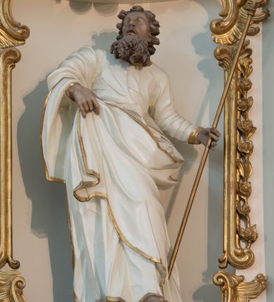 Zdjęcie nr 21: Nastawa architektoniczna, trójosiowa, dwukondygnacyjna ze zwieńczeniem, ustawiona na dwustrefowym cokole. Ołtarz drewniany, prostopadłościenny z drewnianą mensą, w partii antepedium dekorowany trzema płycinami. Na ołtarzu ustawione tabernakulum. Cokół dwustrefowy z wyodrębnionymi prostopadłościanami dekorowanymi w pierwszej strefie płycinami, w drugiej rocaille'owymi płycinami.  Osie pierwszej kondygnacji wydzielone trzema parami kolumn. Oś środkowa flankowana dwiema parami pilastrów i stojącymi przed nimi kolumnami ustawionymi na cokołach, druga para zwrócona pod kątem na zewnątrz. Podpory dźwigają wyłamane na ich osi fragmenty belkowania, środkowa para również przerwany, falisty przyczółek. Na belkowaniu i przyczółku siedzi para puttów i para adorujących aniołów. Pomiędzy parami kolumn ustawione figury św. Anny i św. Elżbiety. W polu głównym znajduje się wnęka w formie stojącego prostokąta zamkniętego łukiem półkolistym nadwieszonym z uskokiem, ujęta profilowaną ramą z obrazem Matki Boskiej z Dzieciątkiem i św. Janem Chrzcicielem. Ponad obrazem rokokowy kartusz z kwiatowymi zwisami, z napisem „EN! / PORTA PATET CURIAE / DEI EXCELSA MATER ET / VIRGO IO! VENITE / S(anctus) Cyprianus”. Osie boczne wydzielone zewnętrzną parą pilastrów i stojących przed nimi kolumn ustawionych na dwustrefowych cokołach, dźwigających imposty i fragmenty przerwanego rocaille'owego przyczółka. Na osiach w partii cokołu znajdują się bramki z drzwiami w kształcie stojącego prostokąta zamkniętego łukiem półkolistym. Ponad nimi na rocaille'owych konsolach, na tle wnęki ujętej rocaille'ową ramą znajdują się figury św. Joachima i Zachariasza. Nad wnękami ażurowa kratka w formie stojącego prostokąta ujęta rocaille'ową ramą. Całość zamknięta rocaille'm z wyodrębnionym pionowym akcentem koguciego grzebienia. Druga kondygnacja flankowana dwiema parami pilastrów, w tym zewnętrzną ustawioną pod kątem na zewnątrz o trzonach przechodzących w spływy wolutowe ustawione na cokołach na belkowaniu pierwszej kondygnacji nastawy. Spływy zakończone są rokokowymi wazonami. Podpory dźwigają gzyms przerwany na polem. Całość zamknięta medalionem z Okiem Opatrzności otoczonym wieńcem z obłoków i uskrzydlonych główek anielskich, w glorii promienistej. U dołu medalionu i na gzymsie znajdują się putta. W polu wnęka w formie stojącego prostokąta zamkniętego łukiem półkolistym nadwieszonym w profilowanej ramie z obrazem św. Kazimierza. Struktura niemal w całości polichromowana w kolorze białym, trzony kolumn polichromowane na sposób imitujący marmoryzację w kolorze biało-różowym, profile i ornamentyka złocone. 