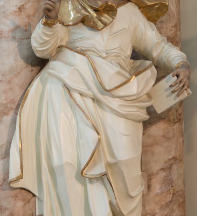 Zdjęcie nr 34: Nastawa architektoniczna, trójosiowa, dwukondygnacyjna ze zwieńczeniem, ustawiona na dwustrefowym cokole. Ołtarz drewniany, prostopadłościenny z drewnianą mensą, w partii antepedium dekorowany trzema płycinami. Na ołtarzu ustawione tabernakulum. Cokół dwustrefowy z wyodrębnionymi prostopadłościanami dekorowanymi w pierwszej strefie płycinami, w drugiej rocaille'owymi płycinami.  Osie pierwszej kondygnacji wydzielone trzema parami kolumn. Oś środkowa flankowana dwiema parami pilastrów i stojącymi przed nimi kolumnami ustawionymi na cokołach, druga para zwrócona pod kątem na zewnątrz. Podpory dźwigają wyłamane na ich osi fragmenty belkowania, środkowa para również przerwany, falisty przyczółek. Na belkowaniu i przyczółku siedzi para puttów i para adorujących aniołów. Pomiędzy parami kolumn ustawione figury św. Anny i św. Elżbiety. W polu głównym znajduje się wnęka w formie stojącego prostokąta zamkniętego łukiem półkolistym nadwieszonym z uskokiem, ujęta profilowaną ramą z obrazem Matki Boskiej z Dzieciątkiem i św. Janem Chrzcicielem. Ponad obrazem rokokowy kartusz z kwiatowymi zwisami, z napisem „EN! / PORTA PATET CURIAE / DEI EXCELSA MATER ET / VIRGO IO! VENITE / S(anctus) Cyprianus”. Osie boczne wydzielone zewnętrzną parą pilastrów i stojących przed nimi kolumn ustawionych na dwustrefowych cokołach, dźwigających imposty i fragmenty przerwanego rocaille'owego przyczółka. Na osiach w partii cokołu znajdują się bramki z drzwiami w kształcie stojącego prostokąta zamkniętego łukiem półkolistym. Ponad nimi na rocaille'owych konsolach, na tle wnęki ujętej rocaille'ową ramą znajdują się figury św. Joachima i Zachariasza. Nad wnękami ażurowa kratka w formie stojącego prostokąta ujęta rocaille'ową ramą. Całość zamknięta rocaille'm z wyodrębnionym pionowym akcentem koguciego grzebienia. Druga kondygnacja flankowana dwiema parami pilastrów, w tym zewnętrzną ustawioną pod kątem na zewnątrz o trzonach przechodzących w spływy wolutowe ustawione na cokołach na belkowaniu pierwszej kondygnacji nastawy. Spływy zakończone są rokokowymi wazonami. Podpory dźwigają gzyms przerwany na polem. Całość zamknięta medalionem z Okiem Opatrzności otoczonym wieńcem z obłoków i uskrzydlonych główek anielskich, w glorii promienistej. U dołu medalionu i na gzymsie znajdują się putta. W polu wnęka w formie stojącego prostokąta zamkniętego łukiem półkolistym nadwieszonym w profilowanej ramie z obrazem św. Kazimierza. Struktura niemal w całości polichromowana w kolorze białym, trzony kolumn polichromowane na sposób imitujący marmoryzację w kolorze biało-różowym, profile i ornamentyka złocone. 