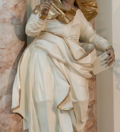 Zdjęcie nr 31: Nastawa architektoniczna, trójosiowa, dwukondygnacyjna ze zwieńczeniem, ustawiona na dwustrefowym cokole. Ołtarz drewniany, prostopadłościenny z drewnianą mensą, w partii antepedium dekorowany trzema płycinami. Na ołtarzu ustawione tabernakulum. Cokół dwustrefowy z wyodrębnionymi prostopadłościanami dekorowanymi w pierwszej strefie płycinami, w drugiej rocaille'owymi płycinami.  Osie pierwszej kondygnacji wydzielone trzema parami kolumn. Oś środkowa flankowana dwiema parami pilastrów i stojącymi przed nimi kolumnami ustawionymi na cokołach, druga para zwrócona pod kątem na zewnątrz. Podpory dźwigają wyłamane na ich osi fragmenty belkowania, środkowa para również przerwany, falisty przyczółek. Na belkowaniu i przyczółku siedzi para puttów i para adorujących aniołów. Pomiędzy parami kolumn ustawione figury św. Anny i św. Elżbiety. W polu głównym znajduje się wnęka w formie stojącego prostokąta zamkniętego łukiem półkolistym nadwieszonym z uskokiem, ujęta profilowaną ramą z obrazem Matki Boskiej z Dzieciątkiem i św. Janem Chrzcicielem. Ponad obrazem rokokowy kartusz z kwiatowymi zwisami, z napisem „EN! / PORTA PATET CURIAE / DEI EXCELSA MATER ET / VIRGO IO! VENITE / S(anctus) Cyprianus”. Osie boczne wydzielone zewnętrzną parą pilastrów i stojących przed nimi kolumn ustawionych na dwustrefowych cokołach, dźwigających imposty i fragmenty przerwanego rocaille'owego przyczółka. Na osiach w partii cokołu znajdują się bramki z drzwiami w kształcie stojącego prostokąta zamkniętego łukiem półkolistym. Ponad nimi na rocaille'owych konsolach, na tle wnęki ujętej rocaille'ową ramą znajdują się figury św. Joachima i Zachariasza. Nad wnękami ażurowa kratka w formie stojącego prostokąta ujęta rocaille'ową ramą. Całość zamknięta rocaille'm z wyodrębnionym pionowym akcentem koguciego grzebienia. Druga kondygnacja flankowana dwiema parami pilastrów, w tym zewnętrzną ustawioną pod kątem na zewnątrz o trzonach przechodzących w spływy wolutowe ustawione na cokołach na belkowaniu pierwszej kondygnacji nastawy. Spływy zakończone są rokokowymi wazonami. Podpory dźwigają gzyms przerwany na polem. Całość zamknięta medalionem z Okiem Opatrzności otoczonym wieńcem z obłoków i uskrzydlonych główek anielskich, w glorii promienistej. U dołu medalionu i na gzymsie znajdują się putta. W polu wnęka w formie stojącego prostokąta zamkniętego łukiem półkolistym nadwieszonym w profilowanej ramie z obrazem św. Kazimierza. Struktura niemal w całości polichromowana w kolorze białym, trzony kolumn polichromowane na sposób imitujący marmoryzację w kolorze biało-różowym, profile i ornamentyka złocone. 