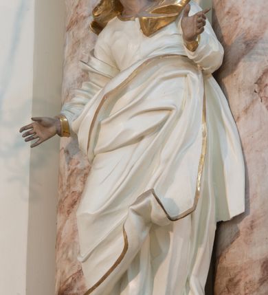 Zdjęcie nr 44: Nastawa architektoniczna, trójosiowa, dwukondygnacyjna ze zwieńczeniem, ustawiona na dwustrefowym cokole. Ołtarz drewniany, prostopadłościenny z drewnianą mensą, w partii antepedium dekorowany trzema płycinami. Na ołtarzu ustawione tabernakulum. Cokół dwustrefowy z wyodrębnionymi prostopadłościanami dekorowanymi w pierwszej strefie płycinami, w drugiej rocaille'owymi płycinami.  Osie pierwszej kondygnacji wydzielone trzema parami kolumn. Oś środkowa flankowana dwiema parami pilastrów i stojącymi przed nimi kolumnami ustawionymi na cokołach, druga para zwrócona pod kątem na zewnątrz. Podpory dźwigają wyłamane na ich osi fragmenty belkowania, środkowa para również przerwany, falisty przyczółek. Na belkowaniu i przyczółku siedzi para puttów i para adorujących aniołów. Pomiędzy parami kolumn ustawione figury św. Anny i św. Elżbiety. W polu głównym znajduje się wnęka w formie stojącego prostokąta zamkniętego łukiem półkolistym nadwieszonym z uskokiem, ujęta profilowaną ramą z obrazem Matki Boskiej z Dzieciątkiem i św. Janem Chrzcicielem. Ponad obrazem rokokowy kartusz z kwiatowymi zwisami, z napisem „EN! / PORTA PATET CURIAE / DEI EXCELSA MATER ET / VIRGO IO! VENITE / S(anctus) Cyprianus”. Osie boczne wydzielone zewnętrzną parą pilastrów i stojących przed nimi kolumn ustawionych na dwustrefowych cokołach, dźwigających imposty i fragmenty przerwanego rocaille'owego przyczółka. Na osiach w partii cokołu znajdują się bramki z drzwiami w kształcie stojącego prostokąta zamkniętego łukiem półkolistym. Ponad nimi na rocaille'owych konsolach, na tle wnęki ujętej rocaille'ową ramą znajdują się figury św. Joachima i Zachariasza. Nad wnękami ażurowa kratka w formie stojącego prostokąta ujęta rocaille'ową ramą. Całość zamknięta rocaille'm z wyodrębnionym pionowym akcentem koguciego grzebienia. Druga kondygnacja flankowana dwiema parami pilastrów, w tym zewnętrzną ustawioną pod kątem na zewnątrz o trzonach przechodzących w spływy wolutowe ustawione na cokołach na belkowaniu pierwszej kondygnacji nastawy. Spływy zakończone są rokokowymi wazonami. Podpory dźwigają gzyms przerwany na polem. Całość zamknięta medalionem z Okiem Opatrzności otoczonym wieńcem z obłoków i uskrzydlonych główek anielskich, w glorii promienistej. U dołu medalionu i na gzymsie znajdują się putta. W polu wnęka w formie stojącego prostokąta zamkniętego łukiem półkolistym nadwieszonym w profilowanej ramie z obrazem św. Kazimierza. Struktura niemal w całości polichromowana w kolorze białym, trzony kolumn polichromowane na sposób imitujący marmoryzację w kolorze biało-różowym, profile i ornamentyka złocone. 