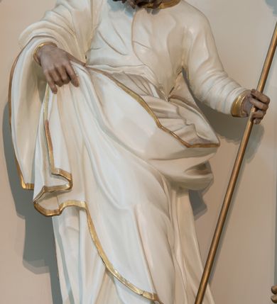 Zdjęcie nr 4: Rzeźba drążona z tyłu, ustawiona na niskiej podstawie. Figura ukazana frontalnie, z lekko uniesioną głową skierowaną w prawo. W lewej, wysuniętej w bok ręce trzyma szuflę pasterską, prawą podtrzymuje z przodu połę płaszcza. Twarz ma pociągła, o starczych rysach, migdałowatych, blisko siebie osadzonych oczach, rozchylonych ustach, okoloną gęstą, długą i kręconą brodą oraz krótkimi włosami rzeźbionymi w pojedyncze pukle. Joachim ubrany jest w długą, białą tunikę ze złoconą lamówką oraz biały płaszcz ze złoconą lamówką zawieszony na prawym ramieniu, otaczający postać, z połą podtrzymywaną z przodu. Ciało polichromowane naturalistycznie. 