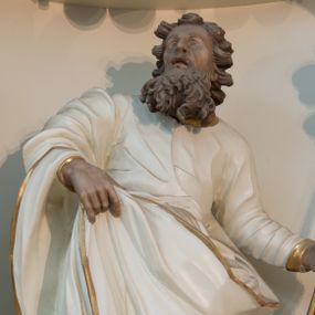 Zdjęcie nr 1: Rzeźba drążona z tyłu, ustawiona na niskiej podstawie. Figura ukazana frontalnie, z lekko uniesioną głową skierowaną w prawo. W lewej, wysuniętej w bok ręce trzyma szuflę pasterską, prawą podtrzymuje z przodu połę płaszcza. Twarz ma pociągła, o starczych rysach, migdałowatych, blisko siebie osadzonych oczach, rozchylonych ustach, okoloną gęstą, długą i kręconą brodą oraz krótkimi włosami rzeźbionymi w pojedyncze pukle. Joachim ubrany jest w długą, białą tunikę ze złoconą lamówką oraz biały płaszcz ze złoconą lamówką zawieszony na prawym ramieniu, otaczający postać, z połą podtrzymywaną z przodu. Ciało polichromowane naturalistycznie. 