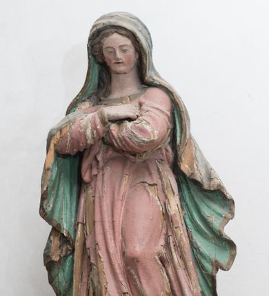 Zdjęcie nr 1: Figura ustawiona na kuli. Maria zwrócona w trzech czwartych w prawo, w kontrapoście, lewą stopą depcze głowę węża, ręce ma skrzyżowane na piersi. Twarz ma owalną, o małych oczach skierowanych w dół, niewielkim nosie i ustach, okoloną długimi włosami, opadającymi na ramiona. Ubrana jest w różową suknię o złoconych lamówkach, obficie fałdowaną, przewiązaną w talii. Na głowę i ramiona ma narzucony zielony płaszcz ze złoconą lamówką, opadający wzdłuż boków i zawieszony na prawym przedramieniu. Polichromia ciała naturalistyczna. 