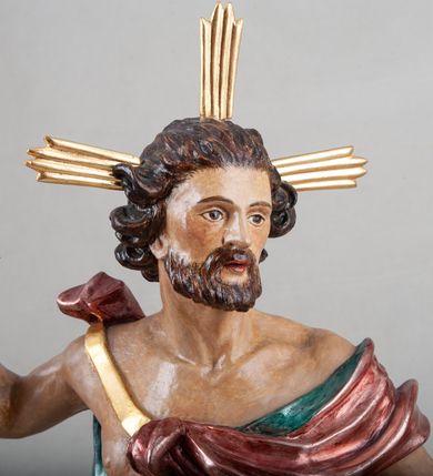 Zdjęcie nr 2: Rzeźba pełna, ustawiona na profilowanym cokole i na rzeźbionej skale. Chrystus zwrócony jest frontalnie, z głową skierowaną w lewą stronę, stoi w silnym kontrapoście. W prawej, uniesionej ręce trzyma drzewce zakończone krzyżem z chorągwią z tkaniny lamowanej koronką, z haftowanym monogramem IHS w glorii, lewą zaś wyciąga w bok. Twarz ma szczupłą, o głęboko osadzonych migdałowatych oczach, niewielkim nosie i małych, pełnych ustach, okoloną brodą oraz krótkimi włosami zaczesanymi do tyłu, układającymi się po bokach w silnie skręcone pukle. Z jego głowy wychodzą trzy wiązki promieni. Chrystus ma przepasane biodra posrebrzonym perizonium. Na prawym ramieniu, na pasku ma zawieszony silnie drapowany i ekspresyjne rozwiany bladoczerwony płaszcz z błękitną podszewką, zarzucony na plecy i na ugiętą prawą nogę. Jego ciało jest szczupłe, o delikatnie zarysowanej, miękko modelowanej muskulaturze torsu i ramion, z zaznaczonymi śladami męki. Na odwrocie podstawy inskrypcja „A(NNO) D(OMINI) / 1781 / A(ntoni) Kornec/ki”. 