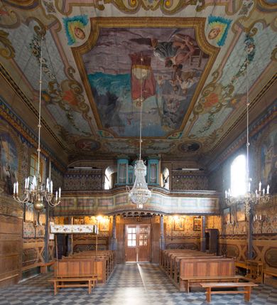 Zdjęcie nr 22: Kościół drewniany o konstrukcji zrębowej, na betonowym podmurowaniu przesłoniętym daszkiem, wieża o konstrukcji słupowej. Elewacje jednolite, szalowane w dolnej połowie pionowo, w górnej połowie poziomo, wzmocnione lisicami. Więźba dachowa drewniana, krokwiowa. Kościół orientowany, jednonawowy, nawa na rzucie prostokąta, prezbiterium nieco węższe, zakończone trójbocznie. Do wschodniej ściany prezbiterium przylega Ogrójec na rzucie prostokąta, od północy piętrowa zakrystia na planie prostokąta z niewielką prostokątną przybudówką od północy. Do zachodniej ściany nawy przylega wieża na planie kwadratu, do południowej ściany nawy kaplica na takim samym planie. 
Pomiędzy nawą a prezbiterium prostokątny otwór tęczowy. Wewnątrz ściany wzmocnione parami lizen, zakończone opasującym całość wnętrza profilowanym gzymsem. Parapet chóru muzycznego w zachodniej części nawy, o wypukłej środkowej części, podparty na czterech filarach. Zakrystia dwupiętrowa ze strychem, na drugim piętrze dawna loża kolatorska otwarta do wnętrza prezbiterium arkadą. Kaplica boczna dwupiętrowa, górne pomieszczenie dzielą od wnętrza dwa okna. Otwory drzwiowe o prostokątnym wykroju, zamknięte drzwiami spągowymi w południowej ścianie nawy oraz prezbiterium, drzwi w zachodniej ścianie dwuskrzydłowe. Wnętrze nakryte pułapami deskowymi o zaokrąglonych fasetach. Posadzka z płyt ceramicznych. 
Elewacja frontowa z dostawioną trójkondygnacyjną, zwężającą się ku górze wieżą, każda kondygnacja oddzielona daszkiem. Na osi oraz na południowej ścianie wejścia do kruchty w przyziemiu wieży z dwuskrzydłowymi drzwiami, frontowe nakryte dwuspadowym daszkiem z niszą na figurę Najświętszego Serca Jezusa. Prostokątne okna z dwóch stron pierwszej kondygnacji, trzech stron drugiej kondygnacji, w partii trzeciej z każdej strony para otworów dzwonnych. W elewacji północnej pięć otworów okiennych w formie stojącego prostokąta, dwa w nawie, po jednym w każdej kondygnacji zakrystii oraz w północnej przybudówce zakrystii wejście i małe prostokątne okienko. W elewacji południowej cztery okna w formie stojącego prostokąta, dwa w nawie i dwa w prezbiterium. W kaplicy bocznej okno i wejście w pierwszej kondygnacji oraz cztery okna w drugiej kondygnacji – dwa na ścianie frontowej oraz po jednym na bocznych. Na ścianie wschodniej prezbiterium Ogrójec w formie głębokiej szalowanej wnęki przesłoniętej dwuspadowym daszkiem. Kościół nakryty dachami dwuspadowymi z ceramicznej dachówki, wyższym nad nawą, niższym nad prezbiterium, nad zakrystią dach dwuspadowy, nad przybudówką pulpitowy. Kaplica przekryta blaszanym dachem dwuspadowym. Wieża zwieńczona hełmem baniastym pokrytym blachą, z ośmioboczną latarnią z otworami dzwonnymi, z pozorną izbicą. W połowie długości dachu nad nawą od strony prezbiterium wznosi się ponad kalenicą wieżyczka na sygnaturkę, na ośmiobocznym obitym blachą trzonie, z latarnią zwieńczoną niewielkim cebulastym, blaszanym hełmem zakończonym kulą z krzyżem. 