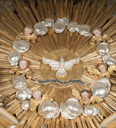 Zdjęcie nr 6: Ołtarz architektoniczny, przyścienny, jednoosiowy, jednokondygnacyjny z mensą. Mensa prosta, kamienna; antepedium płaskorzeźbione ze sceną Zesłania Ducha Świętego. Kompozycja jest niemal symetryczna, postacie apostołów oraz dwie Marie siedzą lub stoją poniżej rozchodzących się promieni glorii. Nastawa ołtarzowa ustawiona na wysokim, zdwojonym cokole, którego szersza oś środkowa jest flankowana parami cokołów ustawionych skośnie. Pierwsza kondygnacja również ustawiona na cokole, którego pola wypełniają płyciny z płaskorzeźbioną, symetryczną dekoracją z ceownicami wokół kwiatu róży. Na środku, na mensie prostopadłościenne tabernakulum na cokole. Na jego ścianie frontowej wypełnione czerwonym kolorem drzwi w kształcie stojącego prostokąta zamkniętego od góry łukiem nadwieszonym, flankowane kolumienkami jońskimi. 
W polu środkowym pierwszej kondygnacji ołtarza obraz „Oblicze Chrystusa” (XVII w.) w profilowanej, prostokątnej ramie z uskokiem i półkolistym zamknięciem od góry. Pole flankowane skośnie ustawionymi kolumnami korynckimi na tle pilastrów, wspierającymi wyłamane nad nimi belkowanie i fragmenty przerwanego przyczółka. Trzony kolumn ozdobione plastycznymi płomieniami. Na pilastrach płyciny z wypełnieniem z płaskorzeźbionych ornamentów o motywach regencyjnych. Na tle pilastrów, po obu stronach środkowego obrazu, rzeźbione figury św. Heleny i św. Barbary w obficie drapowanych szatach. 
Zwieńczenie ołtarza w formie glorii promienistej z gołębicą Ducha Świętego pośrodku. Poniżej niej, na banderoli inskrypcja „EMITTE  SPIRITUM TUUM ET CREABUNTUR”. Przedstawienie ujęte otokiem utworzonym z obłoków i uskrzydlonych główek. Po bokach, na częściach przerwanego belkowania, na obłokach siedzą putta. Są zwrócone do siebie i spoglądają lekko w dół. Mają uniesione ręce i są przepasane złotymi szarfami. 
Struktura ołtarza dekorowana imitacją marmoryzacji za pomocą polichromii na kolor jasnoszary z ciemniejszymi żyłkami; profile, ornamenty, gloria, szaty świętych złocone; obłoki, gołębica, elementy strojów, fragmenty antepedium srebrzone; polichromia w partiach ciała postaci naturalistyczna. 