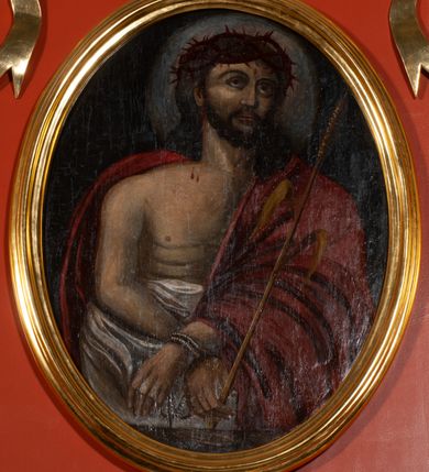 Zdjęcie nr 4: Ołtarz architektoniczny, przyścienny, jednokondygnacyjny, jednoosiowy, w formie podwójnej aediculi. Mensa prostopadłościenna, z płyciną w kształcie leżącego prostokąta wypełnionego marmoryzacją i obwiedzionego profilowaną ramą. Na mensie tabernakulum na planie zbliżonym do owalu, o wklęsło-wypukłej linii ścian. Części boczne na cokole, w środkowej drzwiczki w kształcie stojącego prostokąta zamkniętego łukiem nadwieszonym z symetryczną dekoracją składającą się z kielicha z hostią otoczoną glorią promienistą na tle kłosów zbóż oraz kiści winogron. Na bocznych ściankach dekoracja z ornamentu rocaille&#039;owego. Tabernakulum od góry zamknięte profilowanym gzymsem. 
Nastawa na wysokim, trójdzielnym cokole dekorowanym prostokątnymi płycinami. W polu głównym rama w kształcie stojącego prostokąta zamkniętego od góry łukiem wklęsło-wypukłym z uskokiem. W niej obraz z przedstawieniem Ecce Homo w owalnej ramie poniżej kokardy uwitej ze złotej wstęgi, i powyżej tabliczki z napisem „O MÓJ JEZU MIŁOSIERDZIA!”. Pole flankowane zakończonymi głowicami jońskimi pilastrami podtrzymującymi proste belkowanie. Przed nimi figury dwóch ewangelistów. Całość ujęta dwiema żłobkowanymi kolumnami o kapitelach kompozytowych, wspierającymi pełne belkowanie zwieńczone trójkątnym przyczółkiem z zatkniętym na szczycie krzyżem łacińskim. Na osi kolumn, na belkowaniu wazony z kwiatami. 
Wokół ramy, na trzonach pilastrów, między belkowaniami oraz na fryzie podtrzymywanym przez kolumny dekoracja z elementów roślinnych w postaci pęków kwiatów z liśćmi lub wici; na środku fryzu dwa skrzyżowane młoty; w polu przyczółka uskrzydlona główka anielska. 
Struktura w kolorze kremowym lub marmoryzowana na kolor różowy; kolumny, profile, ornamenty i dekoracje złocone; skrzyżowane młoty, elementy kwiatów i krzyża srebrzone. 