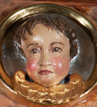 Zdjęcie nr 22: Ołtarz architektoniczny, przyścienny, jednokondygnacyjny, jednoosiowy, w formie aediculi, ustawiony na wysokim cokole. Do niego przystawiona prostopadłościenna mensa, z antepedium ozdobionym trzema płycinami: zewnętrze mają kształt kwadratu i są wypełnione polichromią imitującą marmoryzację, środkowa, w kształcie leżącego prostokąta, ozdobiona jest monogramem maryjnym. Na mensie tabernakulum z tronem do wystawiania, na rzucie zbliżonym do owalu. Ustawione na wysokim cokole, w którym prostokątne drzwiczki. Tron do wystawiania w formie dekorowanej kotarą niszy wypełnionej grupą Ukrzyżowania z Marią i św. Janem, utrzymanej w stylistyce ludowej. Na cokole przedstawiono narzędzia murarskie oraz Serce Jezusa. Niszę flankują pary kolumn, całość wieńczy silnie profilowane belkowanie.  
Nastawa ołtarzowa na własnym cokole z wyodrębnionymi po bokach prostopadłościennymi postumentami pod znajdujące się wyżej kolumny, dekorowanymi od przodu prostokątnymi płycinami; inne powierzchnie partii cokołowej ołtarza (m.in. po bokach tabernakulum) ożywione prostokątnymi, zestawionymi względem siebie w symetryczne pary płycinami, każda ze ściętym jednym z górnych narożników. W polu centralnym środkowej partii retabulum rama w kształcie pionowego prostokąta zamkniętego od góry łukiem wklęsło-wypukłym z uskokiem. W niej obraz z przedstawieniem Matki Boskiej w typie Śnieżnej trzymającej szkaplerz, wyobrażonej poniżej monogramu maryjnego uwitego ze złotej wstęgi. Pole flankowane pilastrami jońskimi, przed którymi ustawione kolumny o kapitelach utworzonych z kimationów, podtrzymujące pełne belkowanie przełamujące się na ich osi. Fryz belkowania dekorowany kolistymi medalionami z głowami aniołków i głową Chrystusa na środku. Przy podstawach kolumn dwie figury ewangelistów. Ponad belkowaniem rozsunięte fragmenty przerwanego, trójkątnego przyczółka. Na belkowaniu, w centrum figura św. Józefa z Dzieciątkiem na lewym ramieniu i lilią w prawej ręce. W zwieńczeniu na osi kolumn figurki siedzących aniołków, trzymających narzędzia murarskie. 
Trzony pilastrów dekorowane kampanulami, ich głowice girlandami kwiatów oraz muszlami; w tle pola głównej kondygnacji gałązki kwiatowe; gzyms tamże w formie fryzu palmetowego, kolejny na mensie.  
Struktura w kolorze kremowym lub pokryta imitacją marmoryzacji w kolorze różowym; niektóre pola malowane na kolor ciemnopomarańczowy; kolumny, profile, ornamenty złocone; elementy figur, medalionów oraz głowic złocone i srebrzone.