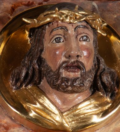 Zdjęcie nr 23: Ołtarz architektoniczny, przyścienny, jednokondygnacyjny, jednoosiowy, w formie aediculi, ustawiony na wysokim cokole. Do niego przystawiona prostopadłościenna mensa, z antepedium ozdobionym trzema płycinami: zewnętrze mają kształt kwadratu i są wypełnione polichromią imitującą marmoryzację, środkowa, w kształcie leżącego prostokąta, ozdobiona jest monogramem maryjnym. Na mensie tabernakulum z tronem do wystawiania, na rzucie zbliżonym do owalu. Ustawione na wysokim cokole, w którym prostokątne drzwiczki. Tron do wystawiania w formie dekorowanej kotarą niszy wypełnionej grupą Ukrzyżowania z Marią i św. Janem, utrzymanej w stylistyce ludowej. Na cokole przedstawiono narzędzia murarskie oraz Serce Jezusa. Niszę flankują pary kolumn, całość wieńczy silnie profilowane belkowanie.  
Nastawa ołtarzowa na własnym cokole z wyodrębnionymi po bokach prostopadłościennymi postumentami pod znajdujące się wyżej kolumny, dekorowanymi od przodu prostokątnymi płycinami; inne powierzchnie partii cokołowej ołtarza (m.in. po bokach tabernakulum) ożywione prostokątnymi, zestawionymi względem siebie w symetryczne pary płycinami, każda ze ściętym jednym z górnych narożników. W polu centralnym środkowej partii retabulum rama w kształcie pionowego prostokąta zamkniętego od góry łukiem wklęsło-wypukłym z uskokiem. W niej obraz z przedstawieniem Matki Boskiej w typie Śnieżnej trzymającej szkaplerz, wyobrażonej poniżej monogramu maryjnego uwitego ze złotej wstęgi. Pole flankowane pilastrami jońskimi, przed którymi ustawione kolumny o kapitelach utworzonych z kimationów, podtrzymujące pełne belkowanie przełamujące się na ich osi. Fryz belkowania dekorowany kolistymi medalionami z głowami aniołków i głową Chrystusa na środku. Przy podstawach kolumn dwie figury ewangelistów. Ponad belkowaniem rozsunięte fragmenty przerwanego, trójkątnego przyczółka. Na belkowaniu, w centrum figura św. Józefa z Dzieciątkiem na lewym ramieniu i lilią w prawej ręce. W zwieńczeniu na osi kolumn figurki siedzących aniołków, trzymających narzędzia murarskie. 
Trzony pilastrów dekorowane kampanulami, ich głowice girlandami kwiatów oraz muszlami; w tle pola głównej kondygnacji gałązki kwiatowe; gzyms tamże w formie fryzu palmetowego, kolejny na mensie.  
Struktura w kolorze kremowym lub pokryta imitacją marmoryzacji w kolorze różowym; niektóre pola malowane na kolor ciemnopomarańczowy; kolumny, profile, ornamenty złocone; elementy figur, medalionów oraz głowic złocone i srebrzone.