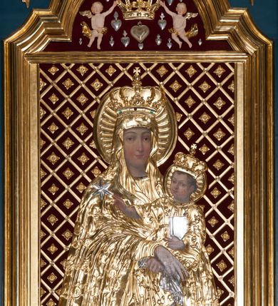 Zdjęcie nr 3: Ołtarz przyścienny, architektoniczny, jednoosiowy, jednokondygnacjowy ze zwieńczeniem. Retabulum ustawione na wysokim, dwukondygnacjowym cokole o wyższej kondygnacji dolnej, z dwoma postumentami wyodrębnionymi po bokach; powierzchnia cokołu dekorowana płycinami w kształcie pionowych prostokątów. Cokół przerwany w środku prostokątnym otworem umożliwiającym dostęp do portalu prowadzącego do krypty kaplicy Morsztynów. Pole centralne ołtarza wypełnia obraz z przedstawieniem Matki Boskiej w typie Śnieżnej, w sukience, zwieńczony przedstawieniem pary aniołów podtrzymujących koronę, umieszczonych pośród wotów. Obraz ujęty w ramę w kształcie pionowego prostokąta zamkniętego łukiem wklęsło-wypukłym z uskokami. Pole z obrazem flankowane jest parami kolumn korynckich, z których zewnętrzne są wysunięte do przodu. Przed nie występują do przodu konsole, na których ustawiono rzeźby św. Jacka i św. Wincentego Ferreriusza. Kolumny dźwigają belkowanie przełamane na ich osiach i wygięte ku górze na linii płytkiego łuku odcinkowego powyżej obrazu; na fryzie przełamanych fragmentów belkowania plakiety utworzone z dekoracji roślinnej; na osiach wewnętrznych kolumn, ponad belkowaniem, wazony z kwiatami. Ponad kolumnami zewnętrznymi i belkowaniem widoczne rozsunięte odcinki półkolistego, pękniętego przyczółka, na których posadowiono figurki aniołków. Pomiędzy odcinkami przyczółka zwieńczenie o formie ścianki w ogólnym kształcie zbliżonej do trapezu, o wklęsłych bokach zakończonych u dołu wolutami, zamkniętej łukiem nadwieszonym; ścianka od góry zwieńczona częściowo niepełnym belkowaniem. Owalne pole pośrodku zwieńczenia wypełnia obraz z przedstawieniem Adoracji Imienia Jezus; po bokach ramy rozmieszczone główki anielskie i plakiety z dekoracją roślinną. Ponad obrazem, na tle gzymsu belkowania od góry zamykającego zwieńczenie, widoczna otwarta księga na tle glorii promienistej i obłoków. Na kartach księgi napis. Struktura retabulum malowana na kolor niebieski; profile, kolumny, ornamenty, detale złocone; figury oraz gloria złocone i srebrzone.