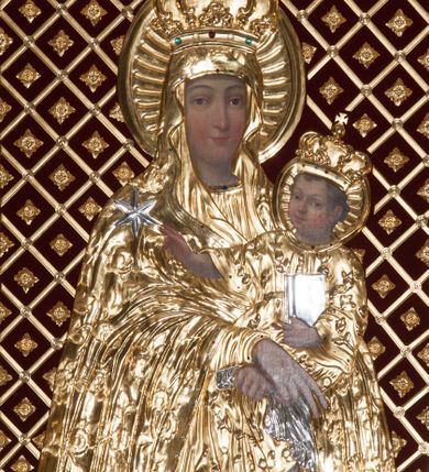 Zdjęcie nr 4: Ołtarz przyścienny, architektoniczny, jednoosiowy, jednokondygnacjowy ze zwieńczeniem. Retabulum ustawione na wysokim, dwukondygnacjowym cokole o wyższej kondygnacji dolnej, z dwoma postumentami wyodrębnionymi po bokach; powierzchnia cokołu dekorowana płycinami w kształcie pionowych prostokątów. Cokół przerwany w środku prostokątnym otworem umożliwiającym dostęp do portalu prowadzącego do krypty kaplicy Morsztynów. Pole centralne ołtarza wypełnia obraz z przedstawieniem Matki Boskiej w typie Śnieżnej, w sukience, zwieńczony przedstawieniem pary aniołów podtrzymujących koronę, umieszczonych pośród wotów. Obraz ujęty w ramę w kształcie pionowego prostokąta zamkniętego łukiem wklęsło-wypukłym z uskokami. Pole z obrazem flankowane jest parami kolumn korynckich, z których zewnętrzne są wysunięte do przodu. Przed nie występują do przodu konsole, na których ustawiono rzeźby św. Jacka i św. Wincentego Ferreriusza. Kolumny dźwigają belkowanie przełamane na ich osiach i wygięte ku górze na linii płytkiego łuku odcinkowego powyżej obrazu; na fryzie przełamanych fragmentów belkowania plakiety utworzone z dekoracji roślinnej; na osiach wewnętrznych kolumn, ponad belkowaniem, wazony z kwiatami. Ponad kolumnami zewnętrznymi i belkowaniem widoczne rozsunięte odcinki półkolistego, pękniętego przyczółka, na których posadowiono figurki aniołków. Pomiędzy odcinkami przyczółka zwieńczenie o formie ścianki w ogólnym kształcie zbliżonej do trapezu, o wklęsłych bokach zakończonych u dołu wolutami, zamkniętej łukiem nadwieszonym; ścianka od góry zwieńczona częściowo niepełnym belkowaniem. Owalne pole pośrodku zwieńczenia wypełnia obraz z przedstawieniem Adoracji Imienia Jezus; po bokach ramy rozmieszczone główki anielskie i plakiety z dekoracją roślinną. Ponad obrazem, na tle gzymsu belkowania od góry zamykającego zwieńczenie, widoczna otwarta księga na tle glorii promienistej i obłoków. Na kartach księgi napis. Struktura retabulum malowana na kolor niebieski; profile, kolumny, ornamenty, detale złocone; figury oraz gloria złocone i srebrzone.