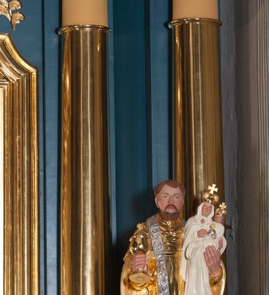 Zdjęcie nr 6: Ołtarz przyścienny, architektoniczny, jednoosiowy, jednokondygnacjowy ze zwieńczeniem. Retabulum ustawione na wysokim, dwukondygnacjowym cokole o wyższej kondygnacji dolnej, z dwoma postumentami wyodrębnionymi po bokach; powierzchnia cokołu dekorowana płycinami w kształcie pionowych prostokątów. Cokół przerwany w środku prostokątnym otworem umożliwiającym dostęp do portalu prowadzącego do krypty kaplicy Morsztynów. Pole centralne ołtarza wypełnia obraz z przedstawieniem Matki Boskiej w typie Śnieżnej, w sukience, zwieńczony przedstawieniem pary aniołów podtrzymujących koronę, umieszczonych pośród wotów. Obraz ujęty w ramę w kształcie pionowego prostokąta zamkniętego łukiem wklęsło-wypukłym z uskokami. Pole z obrazem flankowane jest parami kolumn korynckich, z których zewnętrzne są wysunięte do przodu. Przed nie występują do przodu konsole, na których ustawiono rzeźby św. Jacka i św. Wincentego Ferreriusza. Kolumny dźwigają belkowanie przełamane na ich osiach i wygięte ku górze na linii płytkiego łuku odcinkowego powyżej obrazu; na fryzie przełamanych fragmentów belkowania plakiety utworzone z dekoracji roślinnej; na osiach wewnętrznych kolumn, ponad belkowaniem, wazony z kwiatami. Ponad kolumnami zewnętrznymi i belkowaniem widoczne rozsunięte odcinki półkolistego, pękniętego przyczółka, na których posadowiono figurki aniołków. Pomiędzy odcinkami przyczółka zwieńczenie o formie ścianki w ogólnym kształcie zbliżonej do trapezu, o wklęsłych bokach zakończonych u dołu wolutami, zamkniętej łukiem nadwieszonym; ścianka od góry zwieńczona częściowo niepełnym belkowaniem. Owalne pole pośrodku zwieńczenia wypełnia obraz z przedstawieniem Adoracji Imienia Jezus; po bokach ramy rozmieszczone główki anielskie i plakiety z dekoracją roślinną. Ponad obrazem, na tle gzymsu belkowania od góry zamykającego zwieńczenie, widoczna otwarta księga na tle glorii promienistej i obłoków. Na kartach księgi napis. Struktura retabulum malowana na kolor niebieski; profile, kolumny, ornamenty, detale złocone; figury oraz gloria złocone i srebrzone.