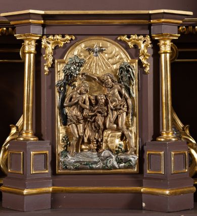 Zdjęcie nr 8: Ołtarz przyścienny, architektoniczny, jednoosiowy, jednokondygnacjowy ze zwieńczeniem. Retabulum ustawione na wysokim cokole, przed którym stoi mensa w typie sarkofagowym. Na mensie tabernakulum w formie prostopadłościanu, którego ściana frontowa jest flankowana parą dostawionych skośnie kolumn, a tylna wolutami. Tabernakulum na cokole, na ścianie frontowej drzwi w kształcie prostokąta zamkniętego od góry łukiem nadwieszonym, z przedstawieniem wypukłorzeźbionej, silnie plastycznej sceny chrztu Chrystusa. Z prawej strony św. Jan Chrzciciel, który prawym kolanem klęczy na głazie, prawą ręką polewa wodą głowę stojącego po lewej stronie Chrystusa. Za nimi dwie postaci, powyżej gołębica Ducha Świętego. W górnych narożnikach ściany frontowej tabernakulum dwa, symetrycznie ułożone ornamenty rocaille. Główne pole właściwego retabulum flankują kolumny korynckie o trzonach dekorowanych wicią, ustawione na tle zwielokrotnionych pilastrów; podpory posadowione na ukośnie ustawionych, rozsuniętych postumentach dekorowanych kwadratowymi płycinami, dźwigają  belkowanie przełamane na ich osiach, z odcinkami także ustawionymi skośnie. W prostokątnym polu głównym nastawy ołtarzowej obraz z przedstawieniem Matki Boskiej Bolesnej poniżej monogramu maryjnego uwitego ze wstęgi, w prostokątnej ramie zamkniętej od góry łukiem nadwieszonym. Górne naroża pola wypełniają płomieniste motywy rocaille przechodzące w dół w fantazyjną wić roślinną.  Na fryzie belkowania umieszczono ornament roślinny z muszlami, a dolna część gzymsu ma formę pasa ażurowej dekoracji z motywów rocaille na czerwonym tle. Na środku tej dekoracji niewielki kartusz z napisem. Na rozsuniętych odcinkach belkowania, na osi kolumn, umieszczone fragmenty pękniętego półkolistego przyczółka; na nich siedzą anioły. Zwieńczenie umieszczone pomiędzy tymi odcinkami w formie ścianki o ogólnym zarysie trapezu o wklęsłych bokach. Wypełnia ją obraz z przedstawieniem św. Antoniego we wklęsło-wypukłej ramie powtarzającej zarys zwieńczenia, które od góry zamknięte jest dwoma wolutami. W miejscu ich styku, na osi, rzeźbione przedstawienie tronującego Boga Ojca pośród chmur, powyżej główek anielskich i na tle glorii promienistej. Bóg prawą rękę wznosi do góry, lewą trzyma na jabłku królewskim i przytrzymuje berło, u stóp gołębica Ducha Świętego. Struktura ołtarza malowana na kolor brązowy; profile, detale, ornamenty i kolumny złocone, postacie w partiach karnacji  polichromowane naturalistycznie.