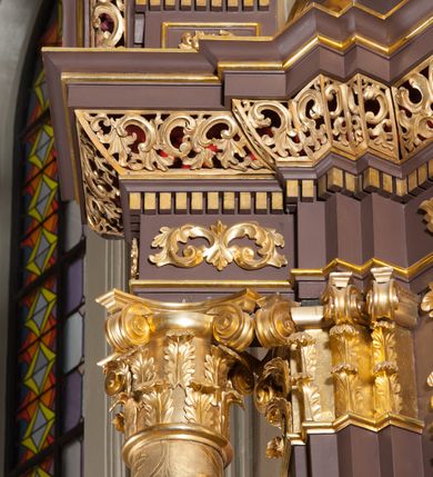 Zdjęcie nr 9: Ołtarz przyścienny, architektoniczny, jednoosiowy, jednokondygnacjowy ze zwieńczeniem. Retabulum ustawione na wysokim cokole, przed którym stoi mensa w typie sarkofagowym. Na mensie tabernakulum w formie prostopadłościanu, którego ściana frontowa jest flankowana parą dostawionych skośnie kolumn, a tylna wolutami. Tabernakulum na cokole, na ścianie frontowej drzwi w kształcie prostokąta zamkniętego od góry łukiem nadwieszonym, z przedstawieniem wypukłorzeźbionej, silnie plastycznej sceny chrztu Chrystusa. Z prawej strony św. Jan Chrzciciel, który prawym kolanem klęczy na głazie, prawą ręką polewa wodą głowę stojącego po lewej stronie Chrystusa. Za nimi dwie postaci, powyżej gołębica Ducha Świętego. W górnych narożnikach ściany frontowej tabernakulum dwa, symetrycznie ułożone ornamenty rocaille. Główne pole właściwego retabulum flankują kolumny korynckie o trzonach dekorowanych wicią, ustawione na tle zwielokrotnionych pilastrów; podpory posadowione na ukośnie ustawionych, rozsuniętych postumentach dekorowanych kwadratowymi płycinami, dźwigają  belkowanie przełamane na ich osiach, z odcinkami także ustawionymi skośnie. W prostokątnym polu głównym nastawy ołtarzowej obraz z przedstawieniem Matki Boskiej Bolesnej poniżej monogramu maryjnego uwitego ze wstęgi, w prostokątnej ramie zamkniętej od góry łukiem nadwieszonym. Górne naroża pola wypełniają płomieniste motywy rocaille przechodzące w dół w fantazyjną wić roślinną.  Na fryzie belkowania umieszczono ornament roślinny z muszlami, a dolna część gzymsu ma formę pasa ażurowej dekoracji z motywów rocaille na czerwonym tle. Na środku tej dekoracji niewielki kartusz z napisem. Na rozsuniętych odcinkach belkowania, na osi kolumn, umieszczone fragmenty pękniętego półkolistego przyczółka; na nich siedzą anioły. Zwieńczenie umieszczone pomiędzy tymi odcinkami w formie ścianki o ogólnym zarysie trapezu o wklęsłych bokach. Wypełnia ją obraz z przedstawieniem św. Antoniego we wklęsło-wypukłej ramie powtarzającej zarys zwieńczenia, które od góry zamknięte jest dwoma wolutami. W miejscu ich styku, na osi, rzeźbione przedstawienie tronującego Boga Ojca pośród chmur, powyżej główek anielskich i na tle glorii promienistej. Bóg prawą rękę wznosi do góry, lewą trzyma na jabłku królewskim i przytrzymuje berło, u stóp gołębica Ducha Świętego. Struktura ołtarza malowana na kolor brązowy; profile, detale, ornamenty i kolumny złocone, postacie w partiach karnacji  polichromowane naturalistycznie.